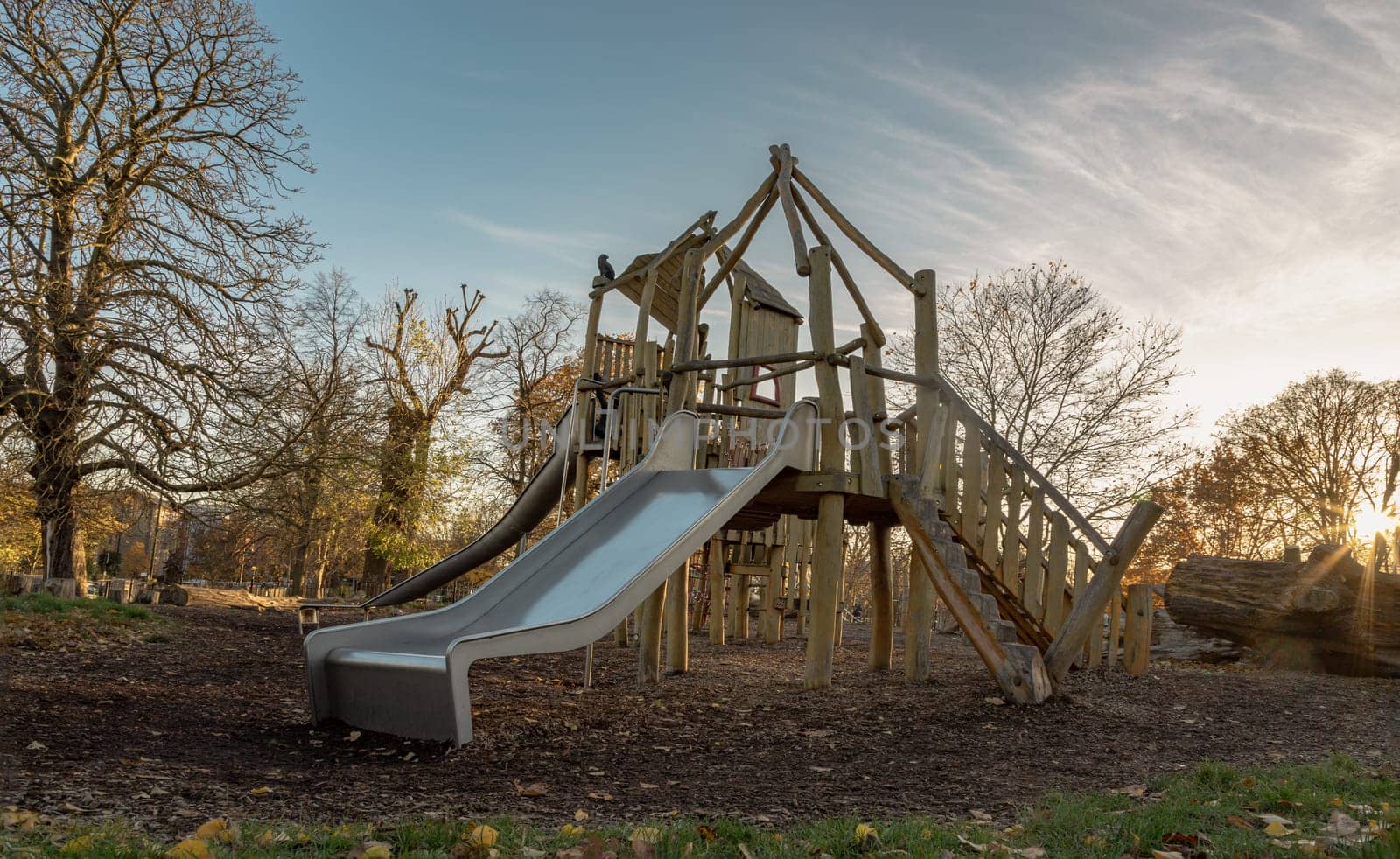 The Children's playground with Slide, Rope Net Bridge made of Wooden Tree trunk in acton park. Empty outdoor playground with wooden equipment for children, Copy space, Selective focus.