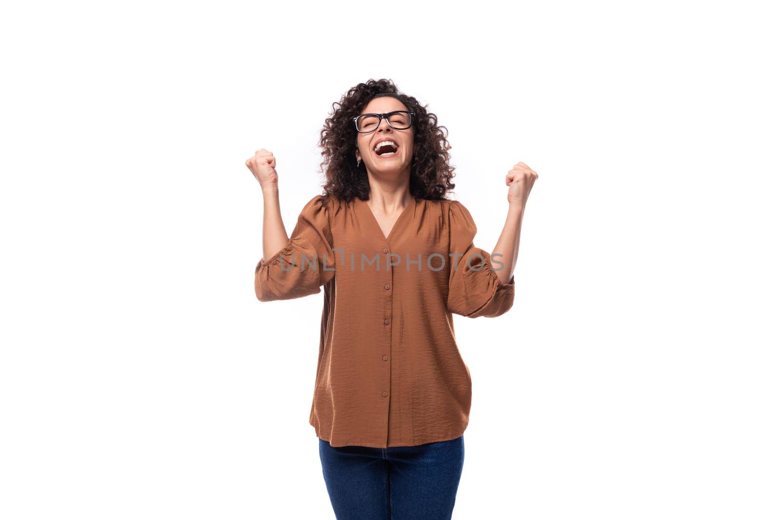 portrait of a cheerful young caucasian curly brunette woman dressed in a beautiful brown shirt.