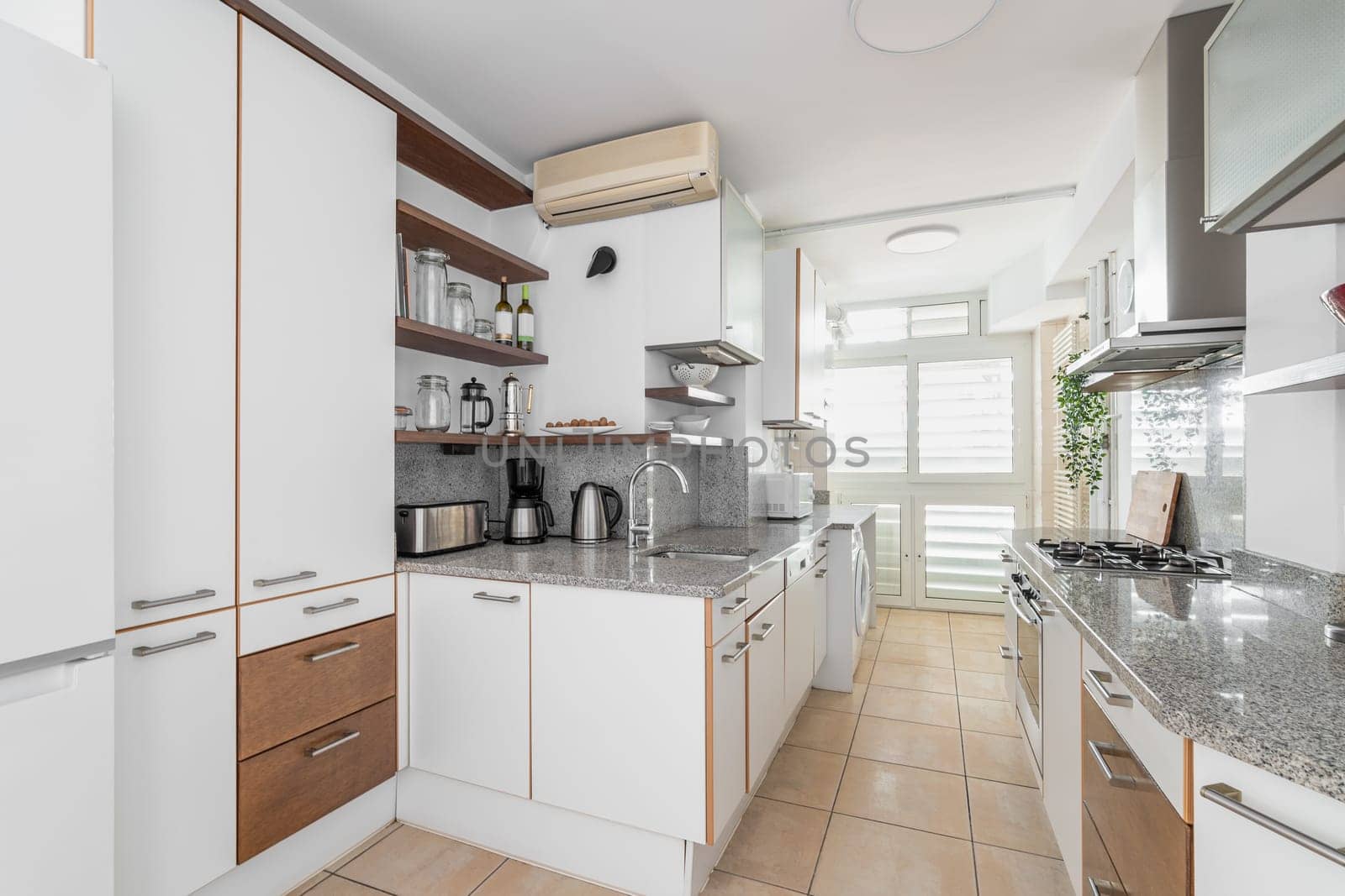 Kitchen unit with different cabinets and cooking appliances in smart apartment. Effective interior design of studio flat. Conveniences for living