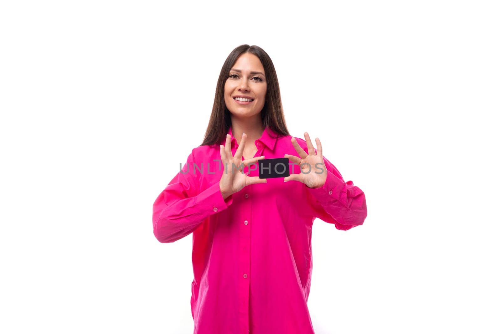 happy positive young brunette lady dressed in bright pink shirt holding plastic credit card by TRMK