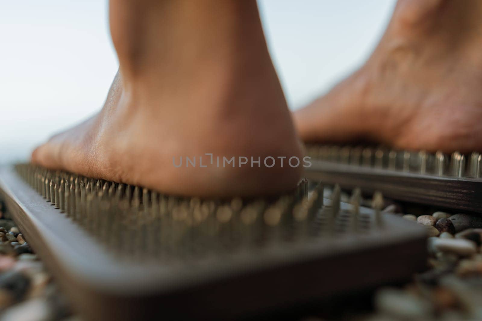 Sea Woman feet stepping on sadhu board during indian practice on the seashore. . Healthy lifestyle concept. tool for working out your inner state.