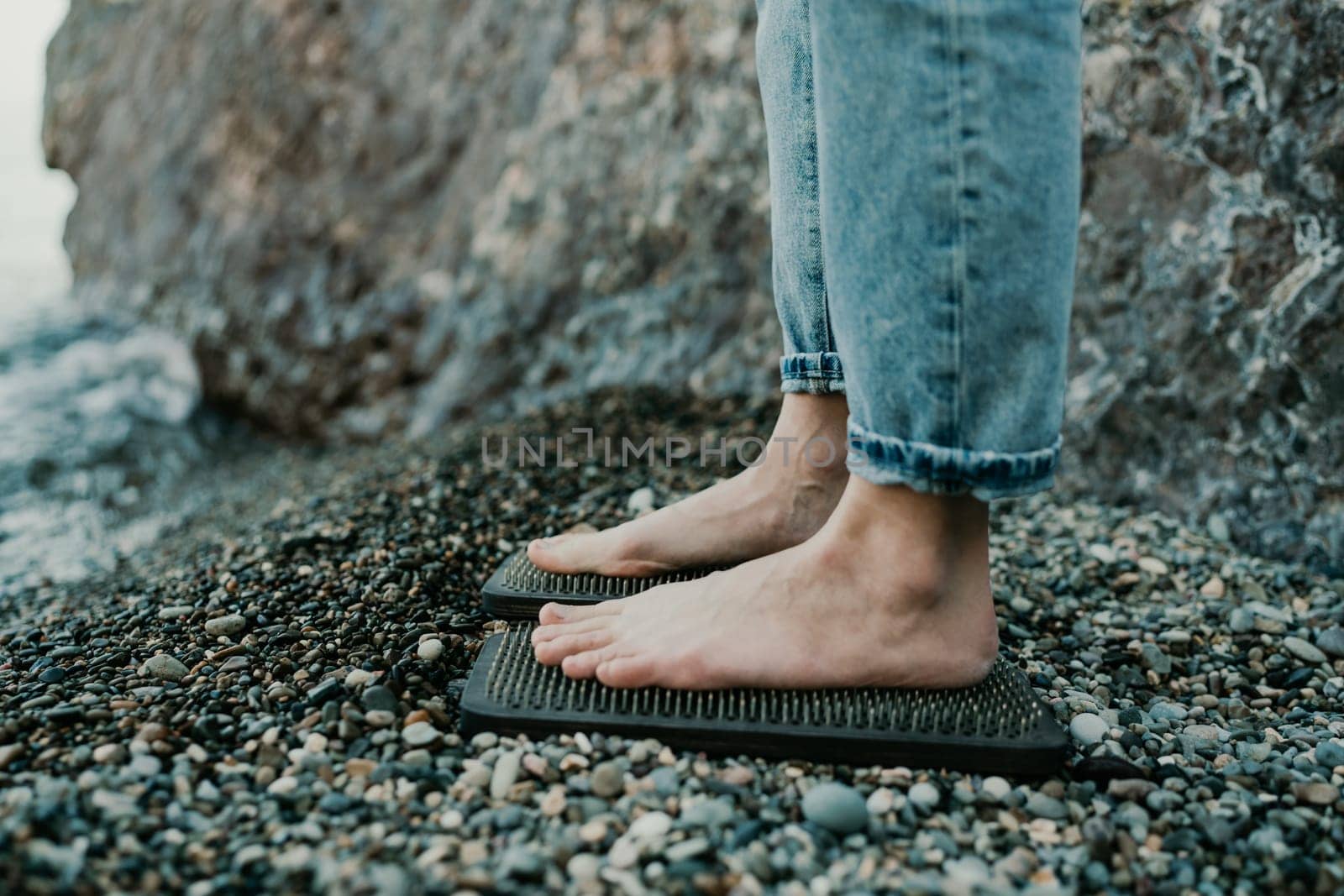 Sea Woman feet stepping on sadhu board during indian practice on the seashore. . Healthy lifestyle concept. tool for working out your inner state.
