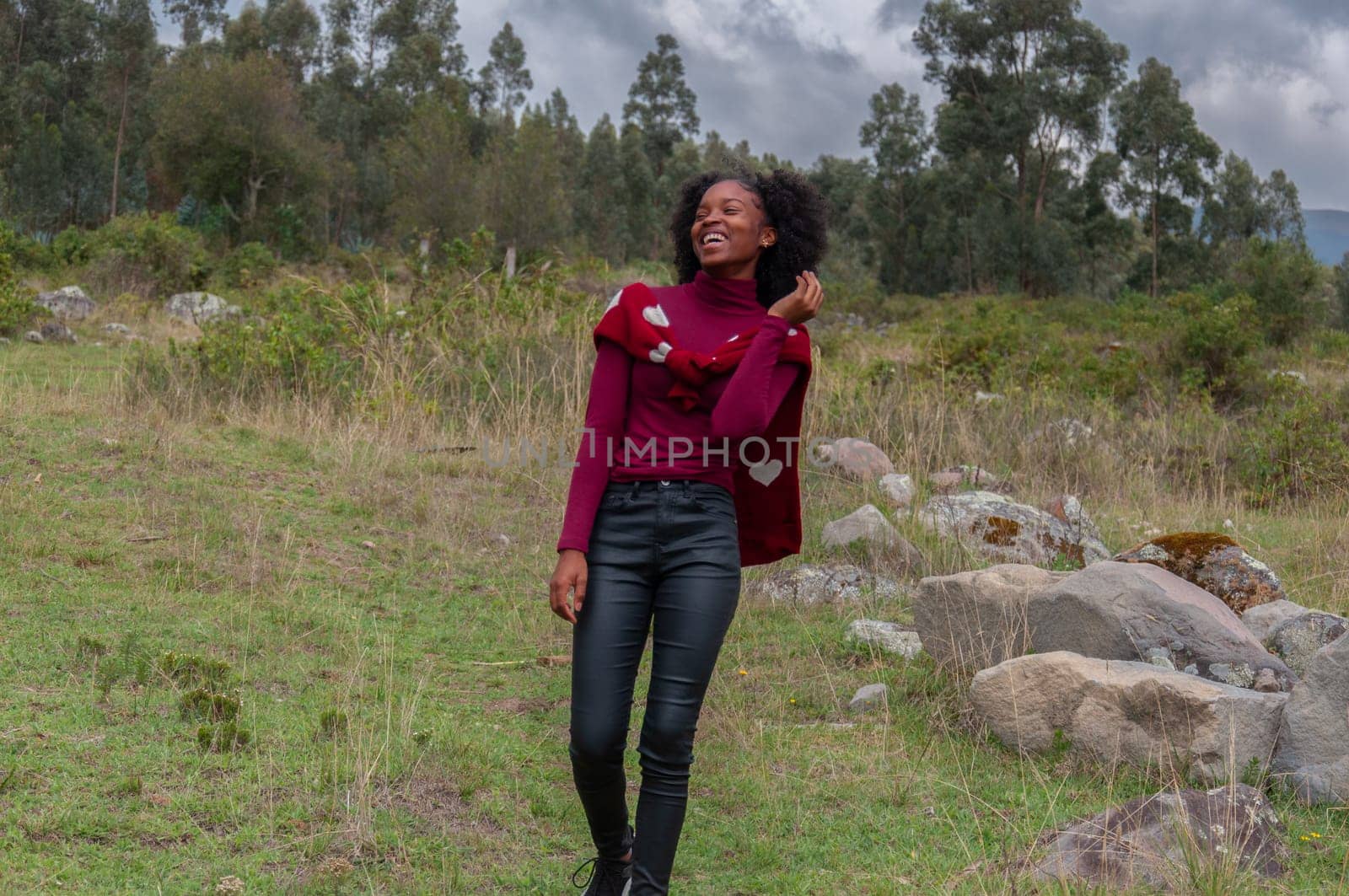 young afro girl on a mountain laughing very naturally and enjoying a lifestyle of beautiful emotions. High quality photo