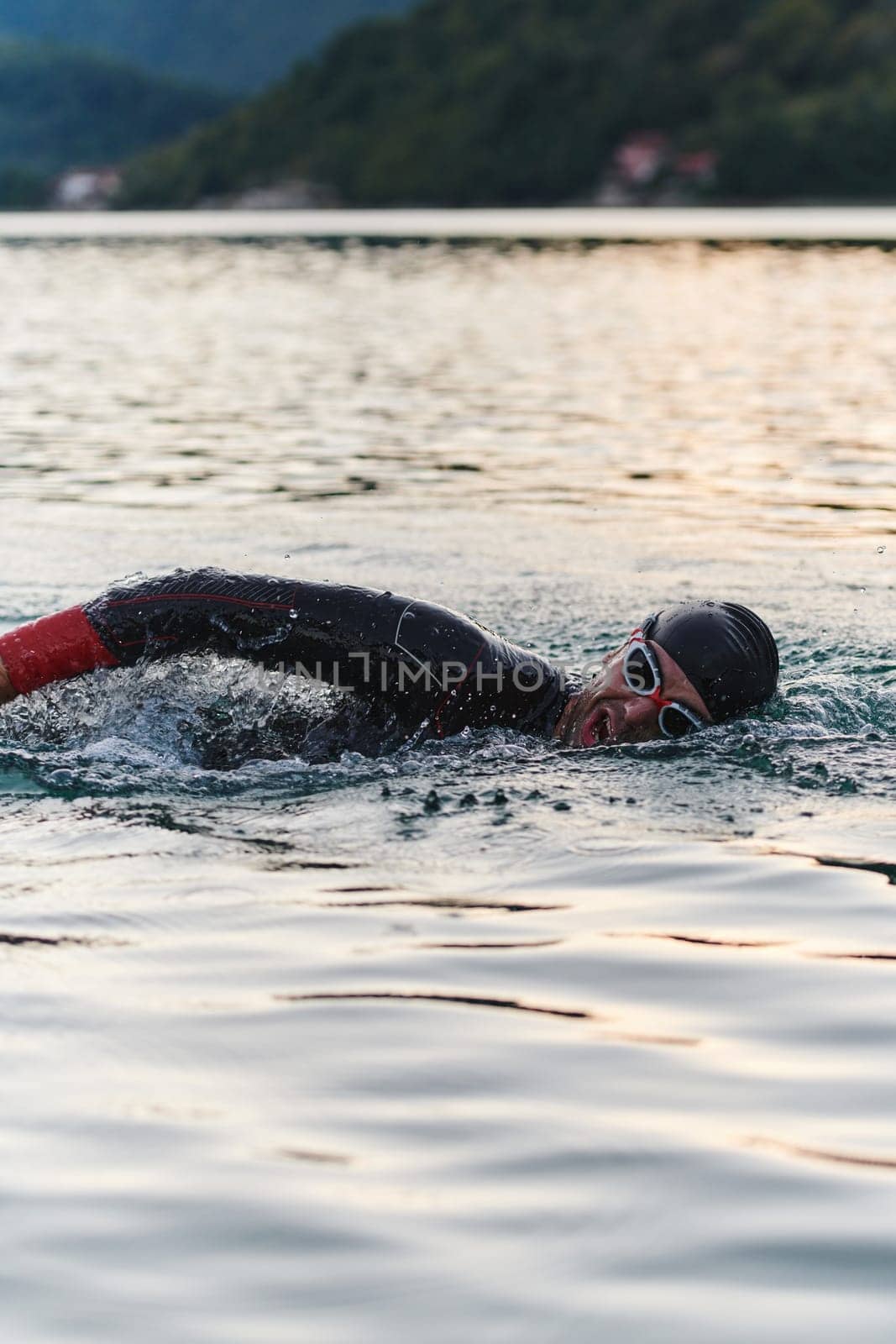 A professional triathlete trains with unwavering dedication for an upcoming competition at a lake, emanating a sense of athleticism and profound commitment to excellence. by dotshock