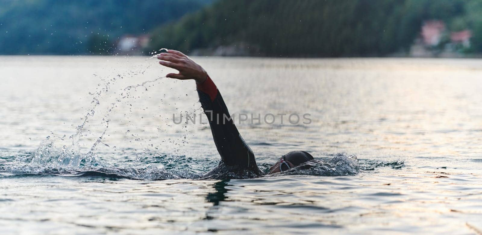 A professional triathlete trains with unwavering dedication for an upcoming competition at a lake, emanating a sense of athleticism and profound commitment to excellence