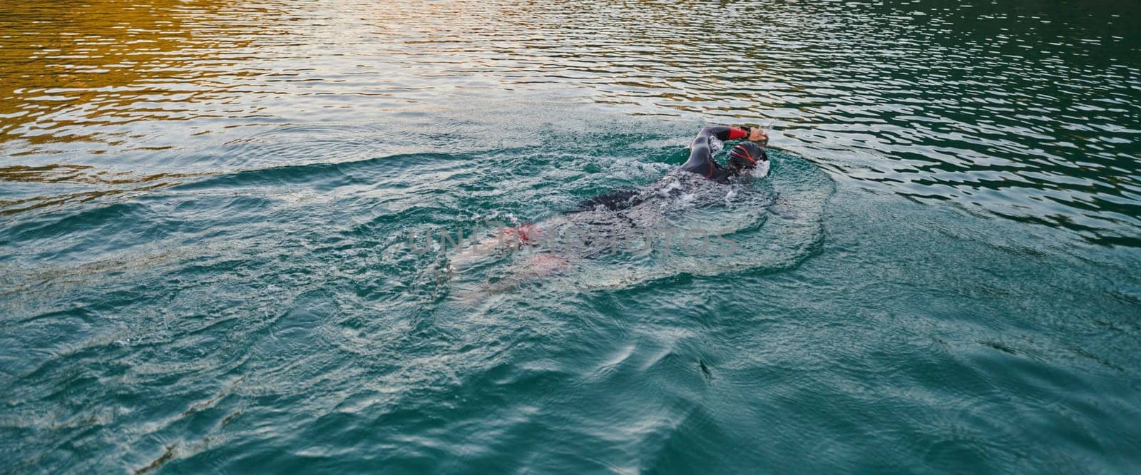 A professional triathlete trains with unwavering dedication for an upcoming competition at a lake, emanating a sense of athleticism and profound commitment to excellence