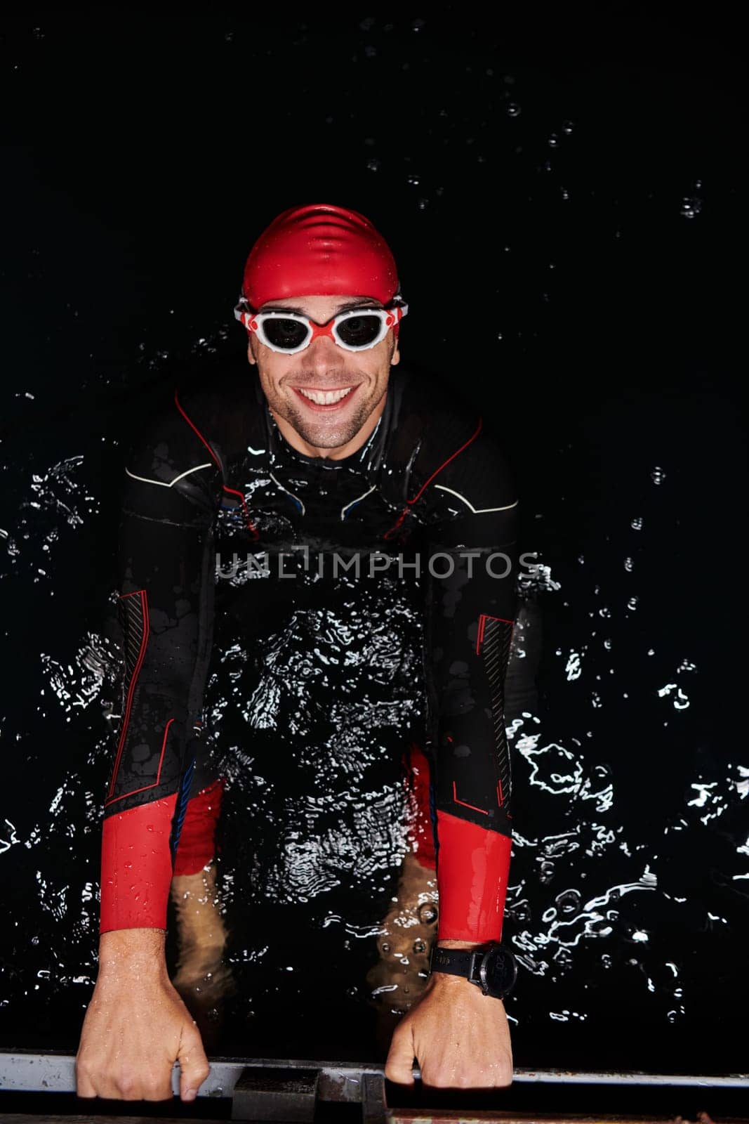 A determined professional triathlete undergoes rigorous night time training in cold waters, showcasing dedication and resilience in preparation for an upcoming triathlon swim competition by dotshock