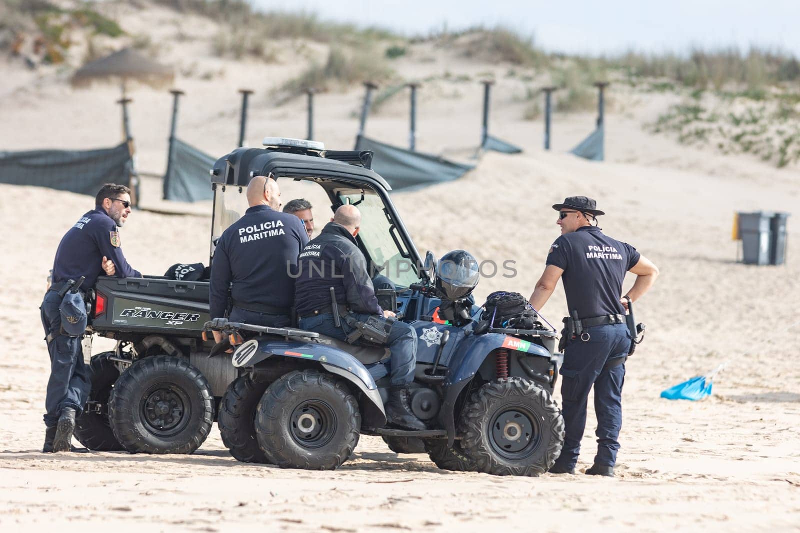 25 november 2023, Lisbon, Portugal - Group of Police Officers guarding on ocean coastline - telephoto