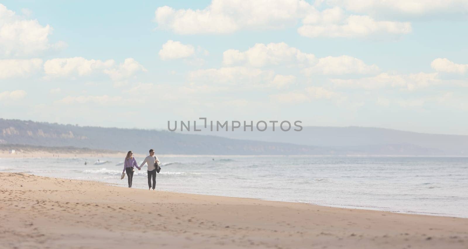 25 november 2023, Lisbon, Portugal - Love couple Walking on a Beach Near the Ocean - telephoto