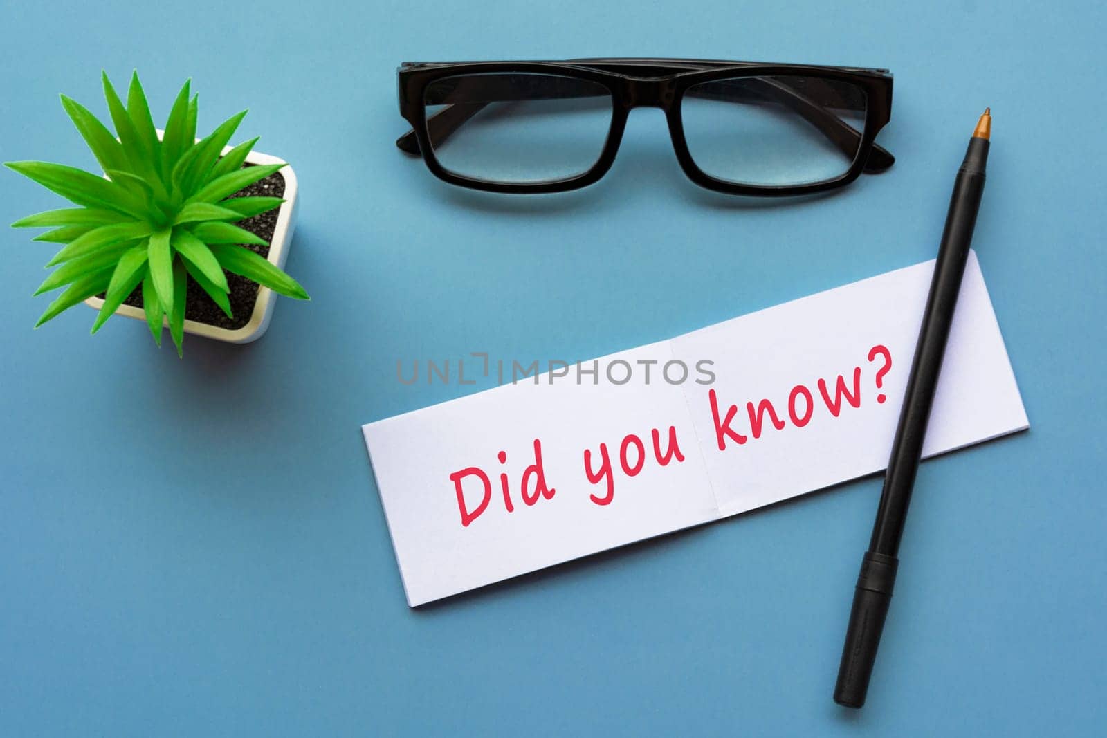 Did you know text written on notepad with pen, reading glasses and potted plant.