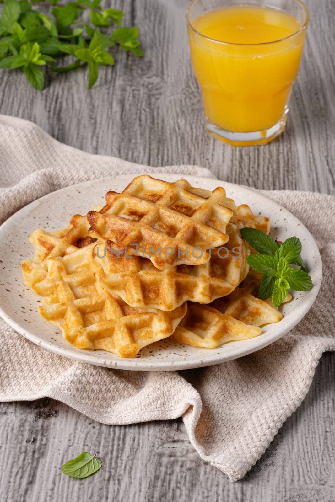 Waffles paired with a glass of freshly squeezed orange juice.