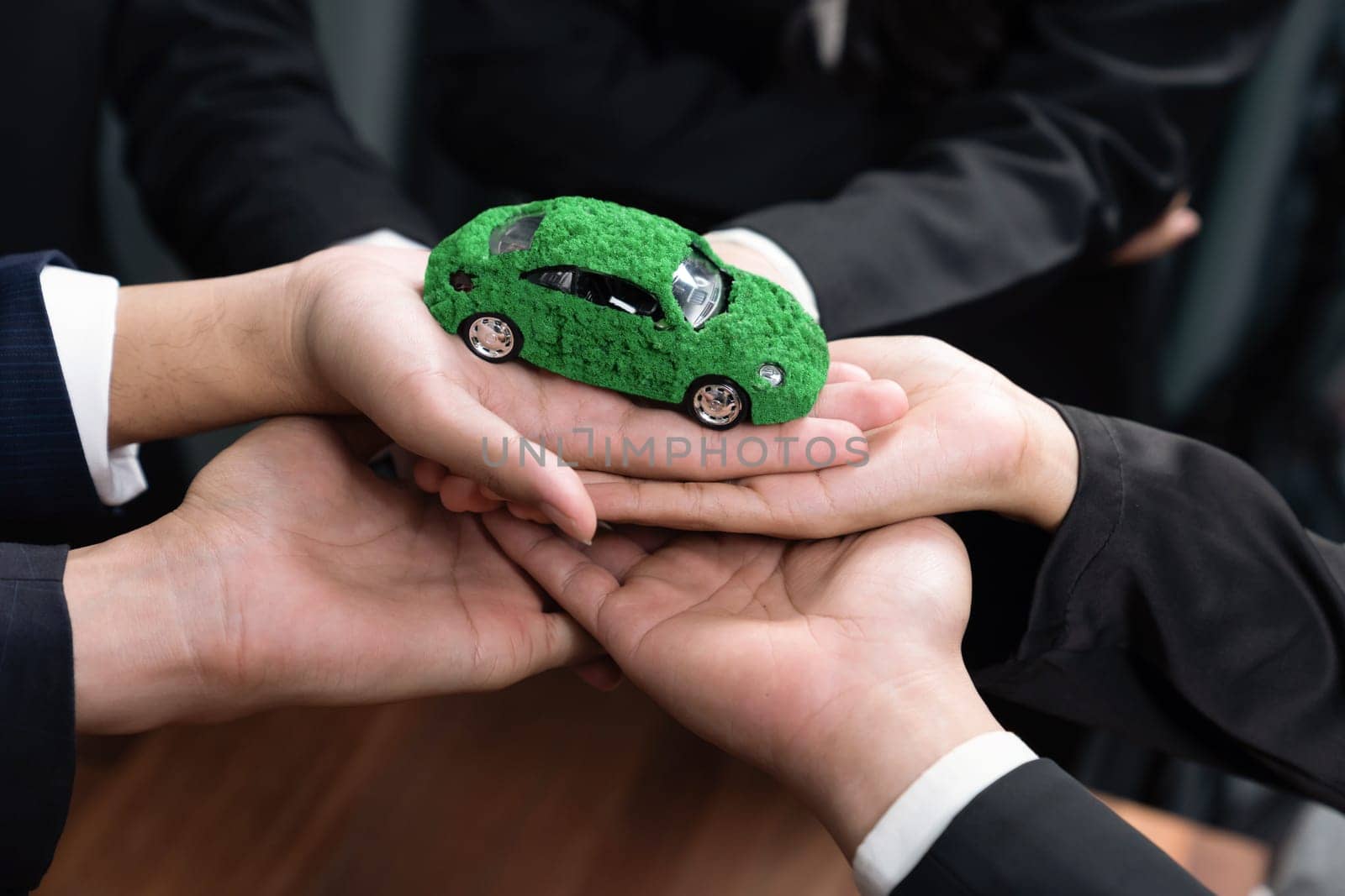 Business people holding EV car model as business synergy partnership unite and take action to utilized eco-transportation to reduce CO2 emission for sustainable and greener future. Quaint