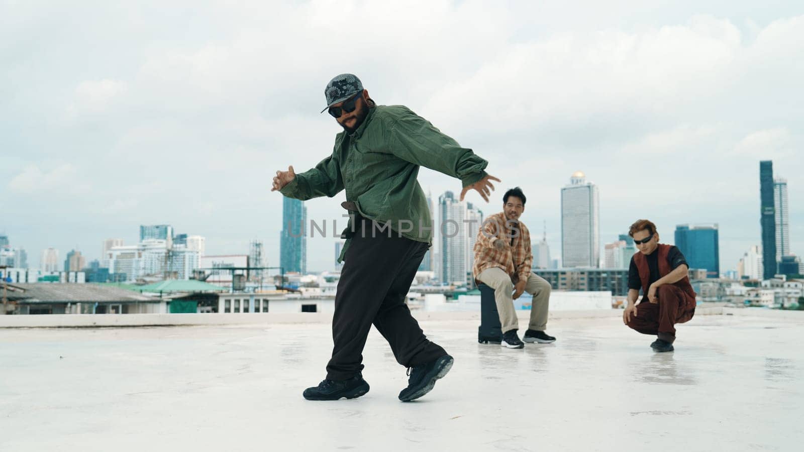 Professional break dance team practice B-boy dance while multicultural friends at rooftop. Young modern dancing group doing hip hop movement. Style,fashion,action. Outdoor sport 2024. Endeavor.