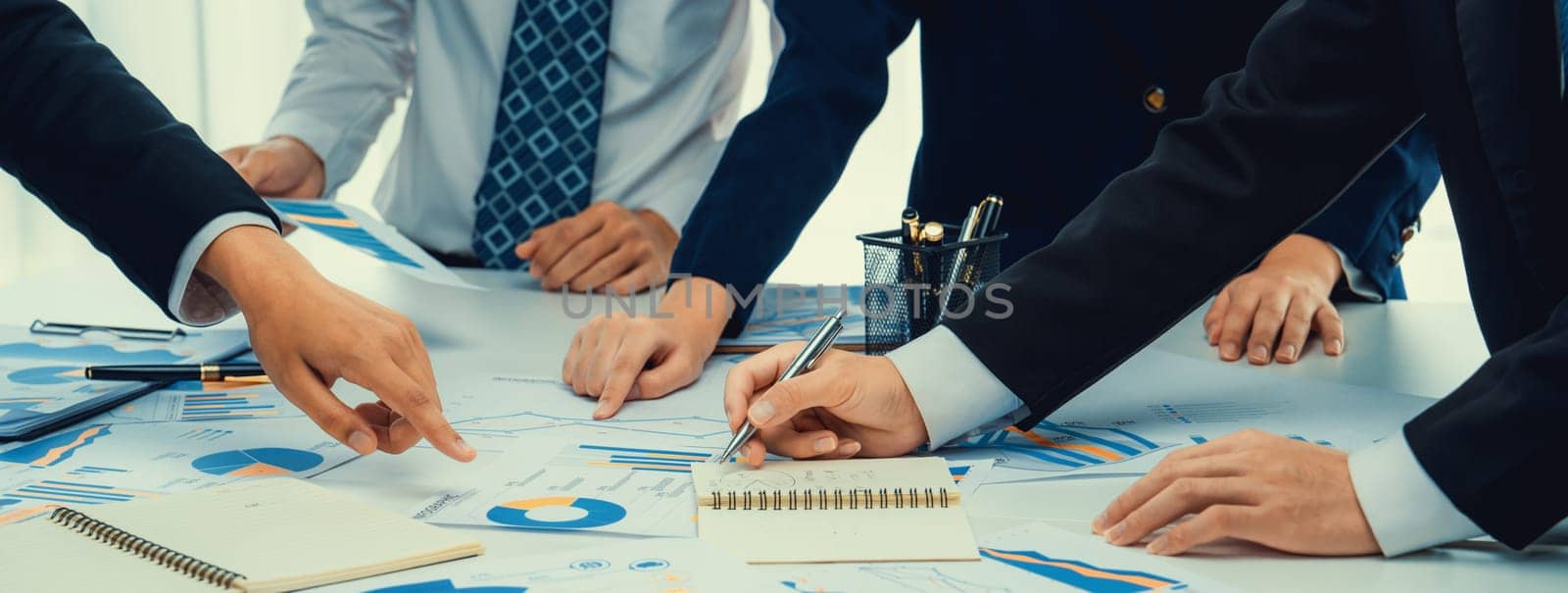 Business people in group meeting in formal attire share idea discussing report for company profit in creative workspace for start up business shot in close up view on group meeting table . Oratory .