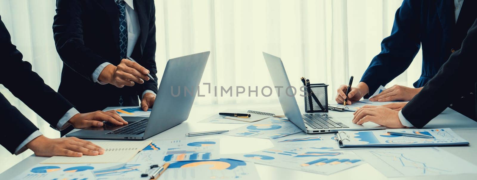 Business people in group meeting in formal attire share idea discussing report for company profit in creative workspace for start up business shot in close up view on group meeting table . Oratory .