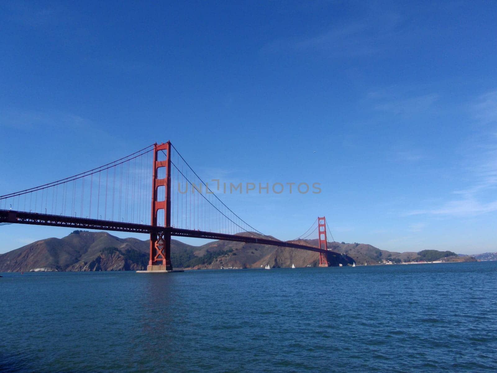 The iconic Golden Gate Bridge in San Francisco, California on a clear day with blue skies and calm waters.
