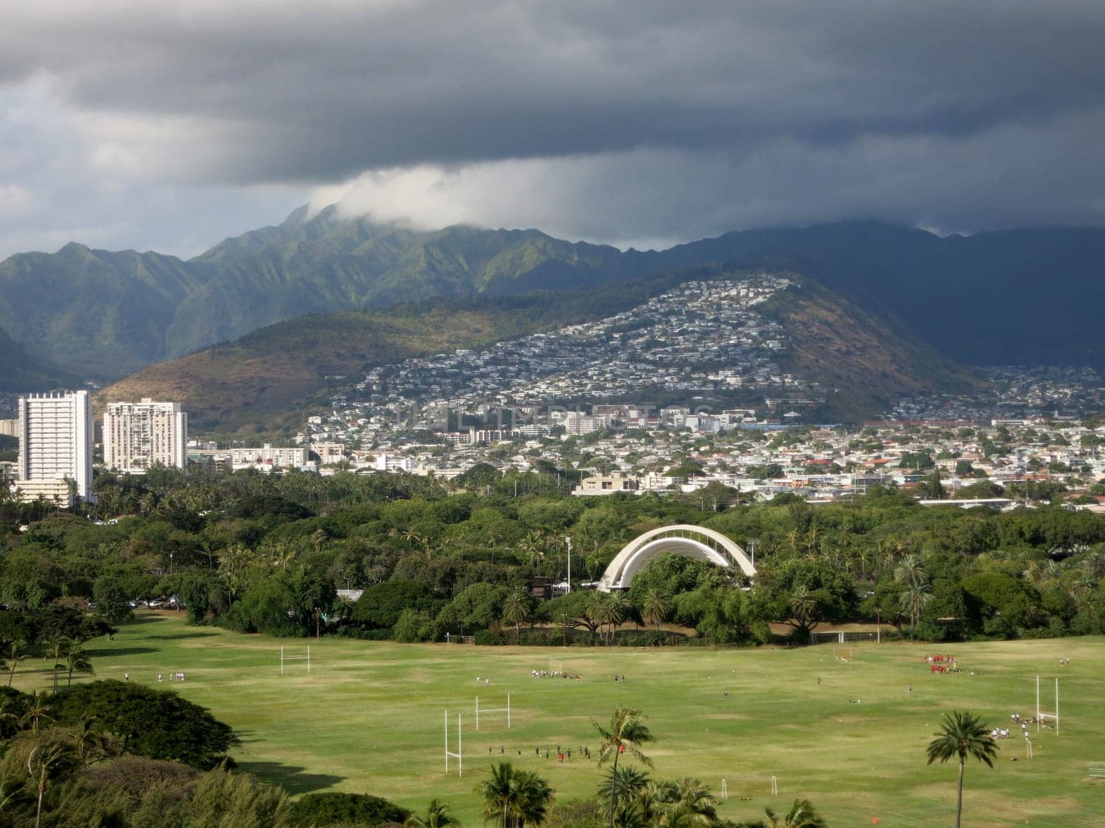 Aerial view of Kapiolani Park in Honolulu, Hawaii with mountains in the background.