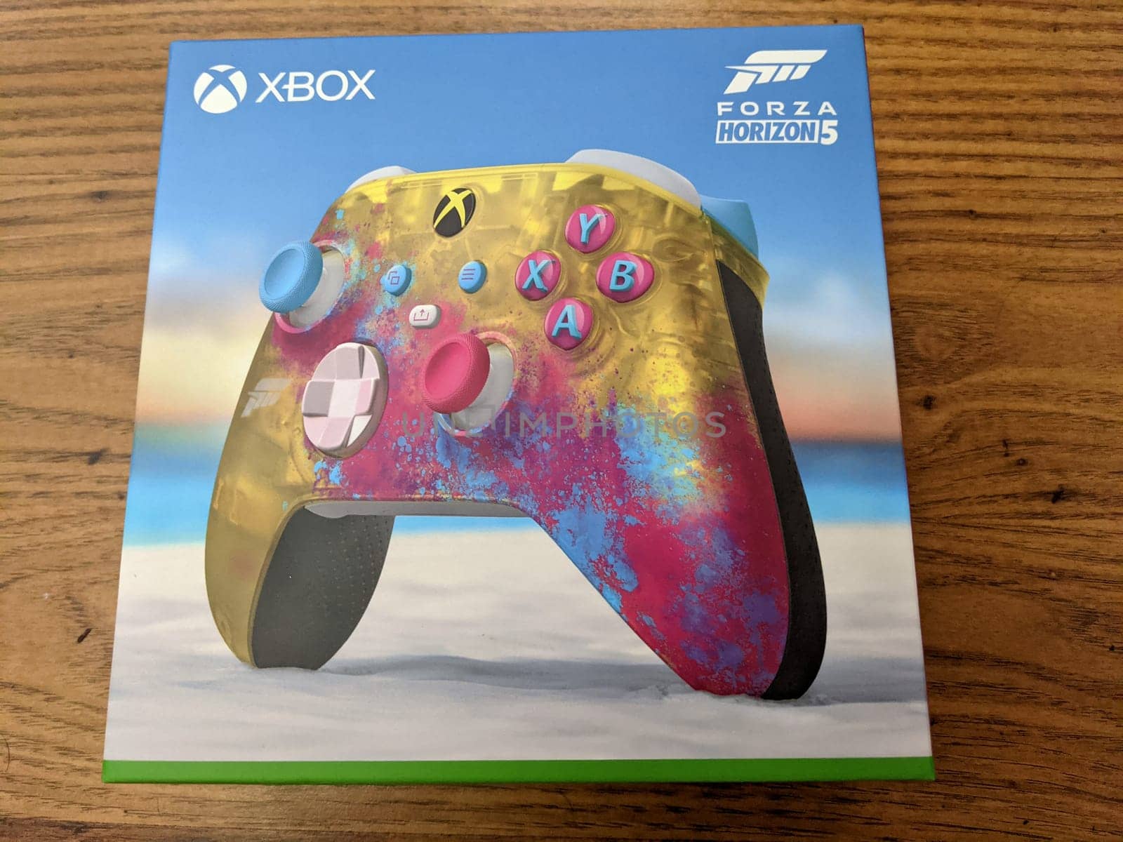 Honolulu - November 9, 2021:  A colorful and unique Xbox controller with a Forza Horizon 5 design. The controller features a transparent yellow finish, a color-shifting hybrid D-pad, and textured grips. The photo shows the Xbox and Horizon 5 logos on the controller and the background.
