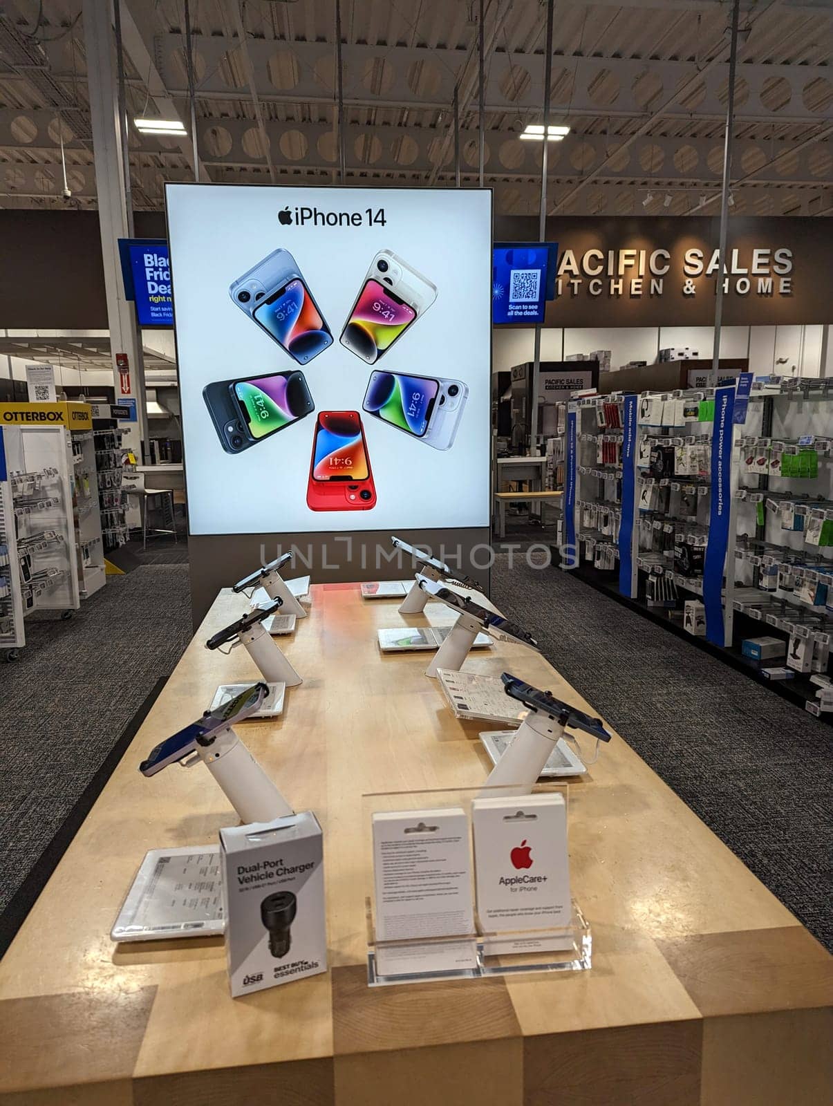 Honolulu - November 1, 2022:   A display of the new iPhone 14 in various colors inside a Best Buy store. The display consists of a large poster and a table with several iPhone 14 models on it. The background shows other electronics and appliances for sale in the store.