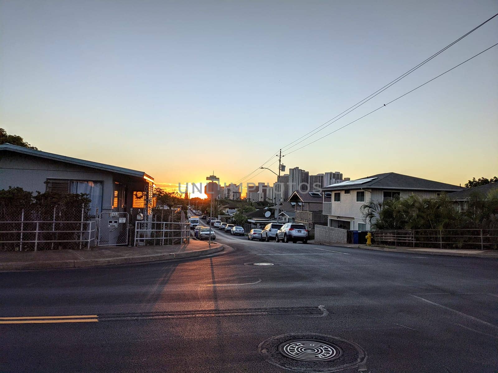 Honolulu -October 20, 2021:  Street in Kapahulu, Hawaii, taken at sunset, with the sun shining between the buildings.