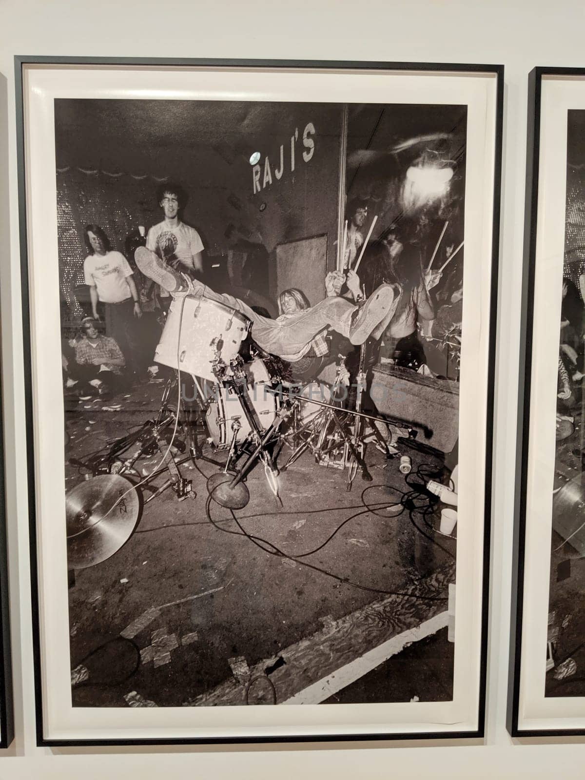 Seattle - May 16, 2019:  American grunge rock band Nirvana performing live at Raji's photo displayed at the Seattle Art Museum. The photo shows lead singer and guitarist Kurt Cobain, bassist Krist Novoselic, and drummer Dave Grohl on stage.  The photo is framed by a white mat and a black metal frame.