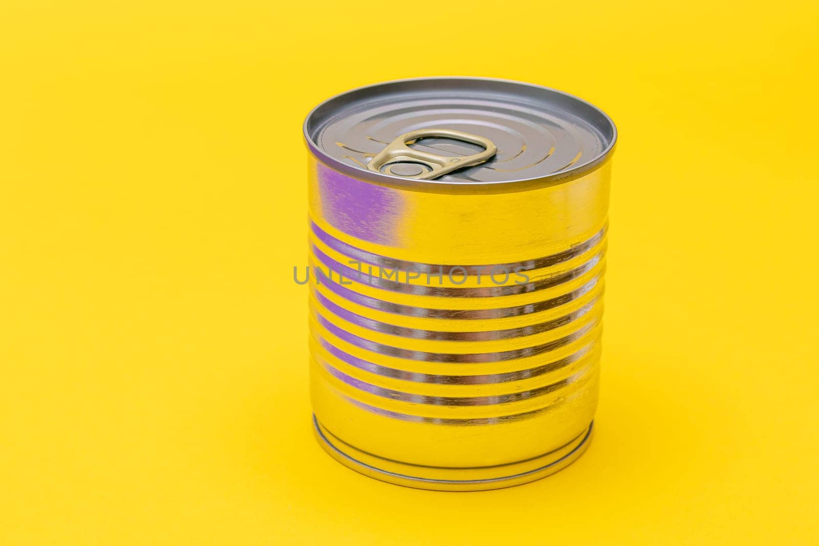 Unopened Tin Can with Blank Edge on Yellow Background. Canned Food. Aluminum Can for Safe and Long Term Storage of Food. Steel Sealed Food Storage Container