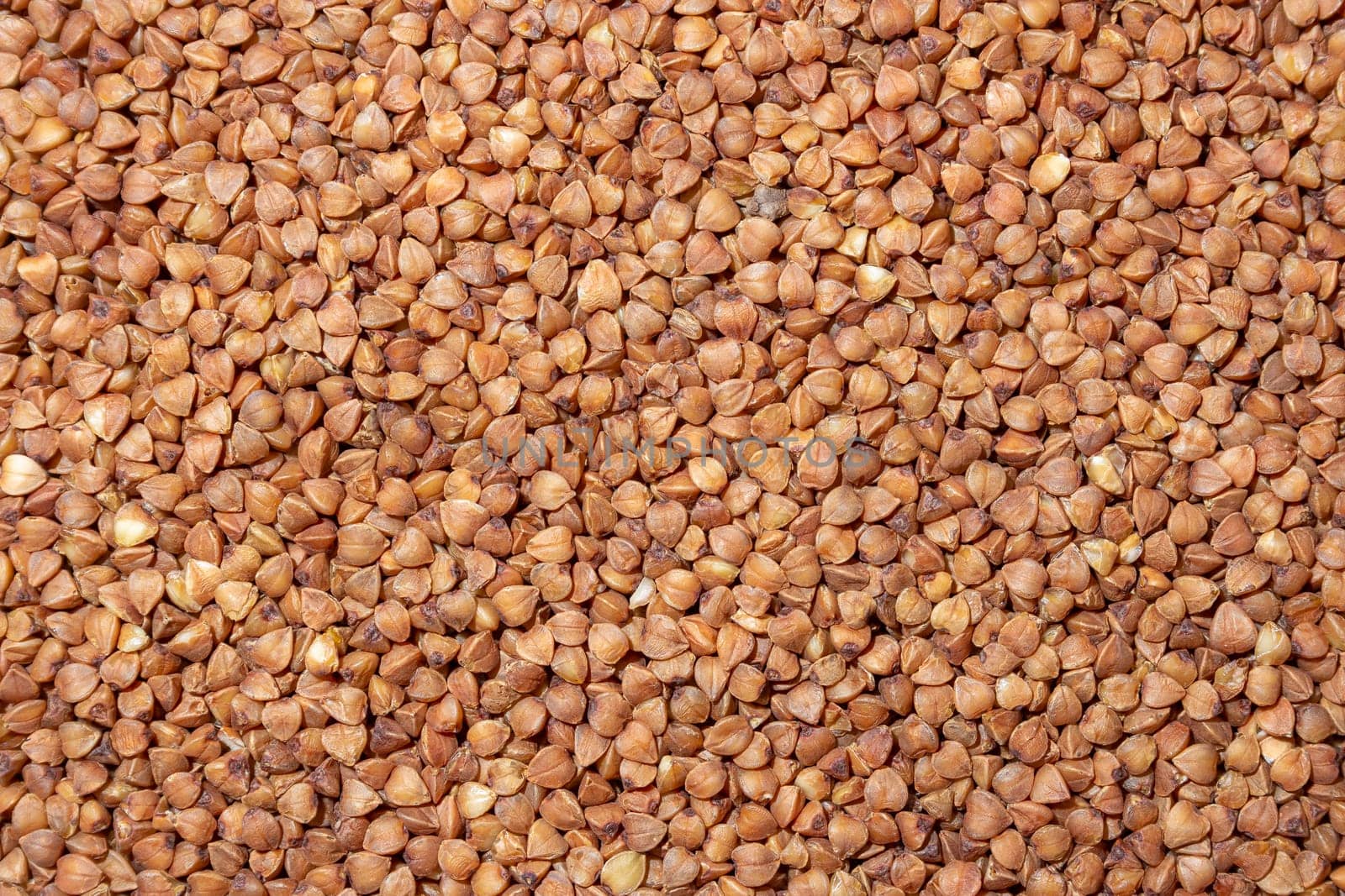 Dry Uncooked Brown Buckwheat Groats Background by InfinitumProdux
