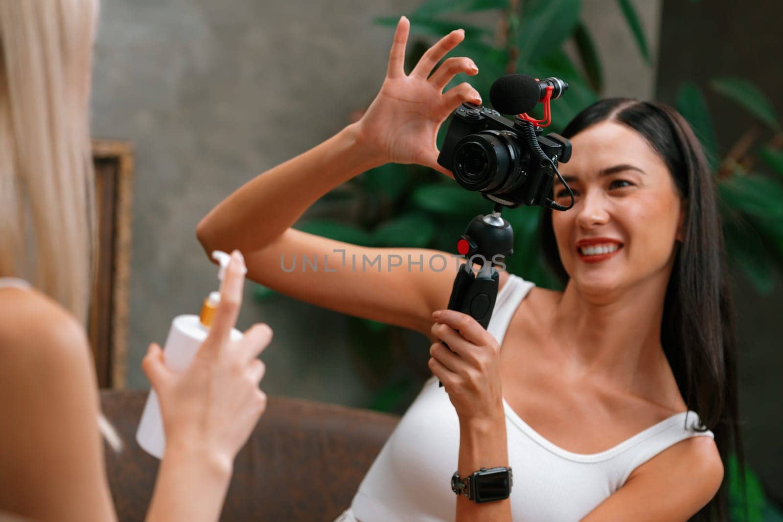 Two beautiful content creator making natural beauty and cosmetic tutorial on green plant leave garden video. Beauty blogger showing how to beauty care to social medial audience by selfie stick. Blithe
