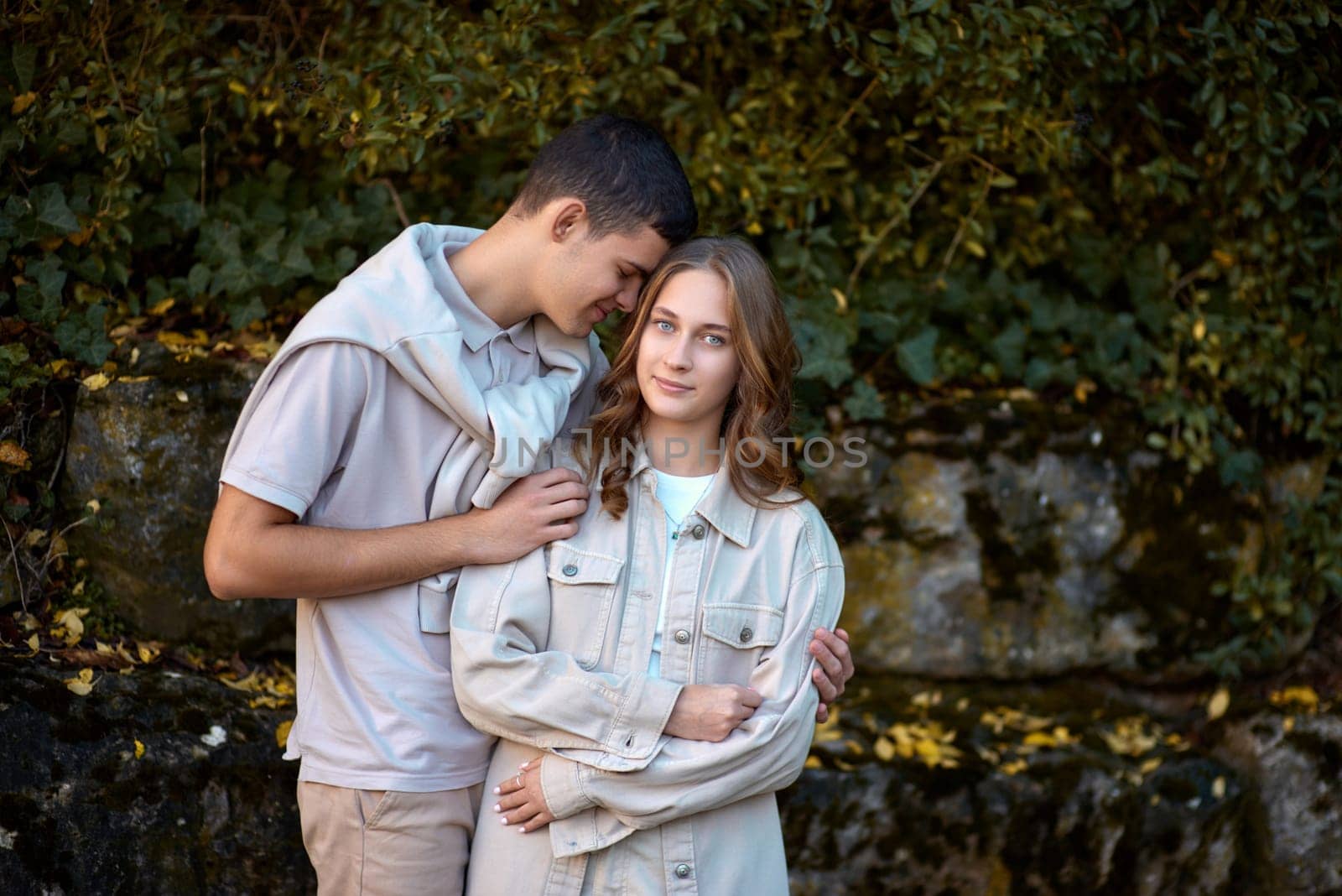 Young Cute Female Hugs Boyfriend. In Autumn Outdoor. Lovers Walking in Park. Attractive Funny Couple. Lovestory in Forest. Man and Woman. Cute Lovers in the Park. Family Concept. Happy Couple.