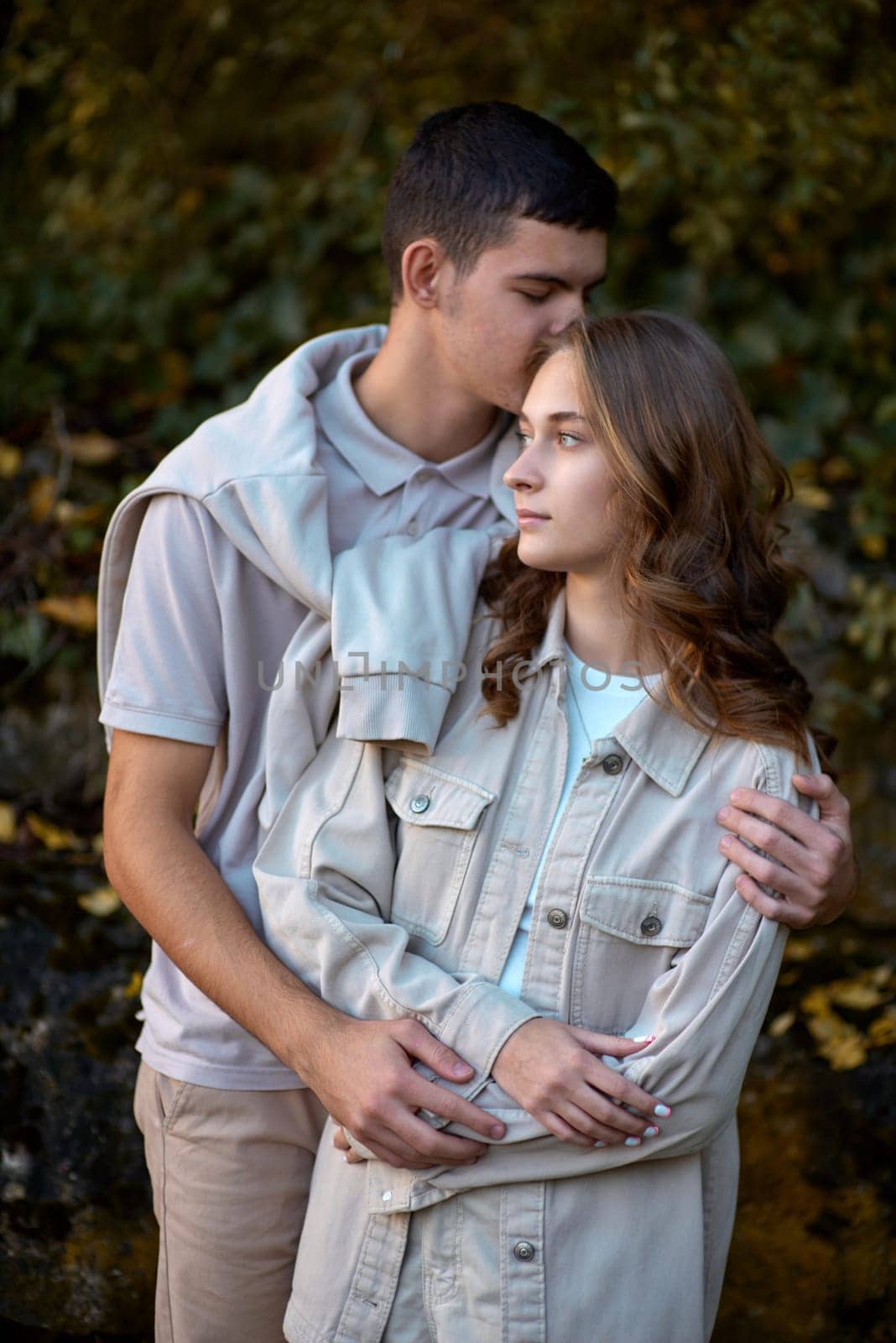 Young Cute Female Hugs Boyfriend. In Autumn Outdoor. Lovers Walking in Park. Attractive Funny Couple. Lovestory in Forest. Man and Woman. Cute Lovers in the Park. Family Concept. Happy Couple. by Andrii_Ko