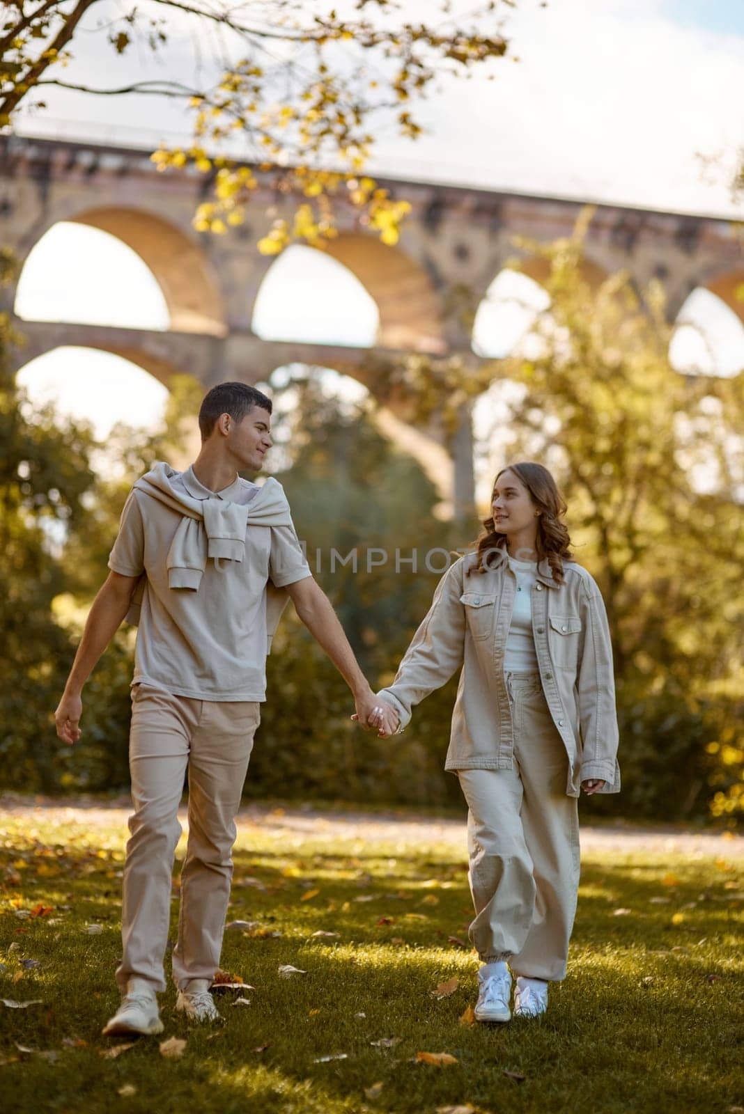 Young Cute Female Hugs Boyfriend. In Autumn Outdoor. Lovers Walking in Park. Attractive Funny Couple. Lovestory in Forest. Man and Woman. Cute Lovers in the Park. Family Concept. Happy Couple. by Andrii_Ko