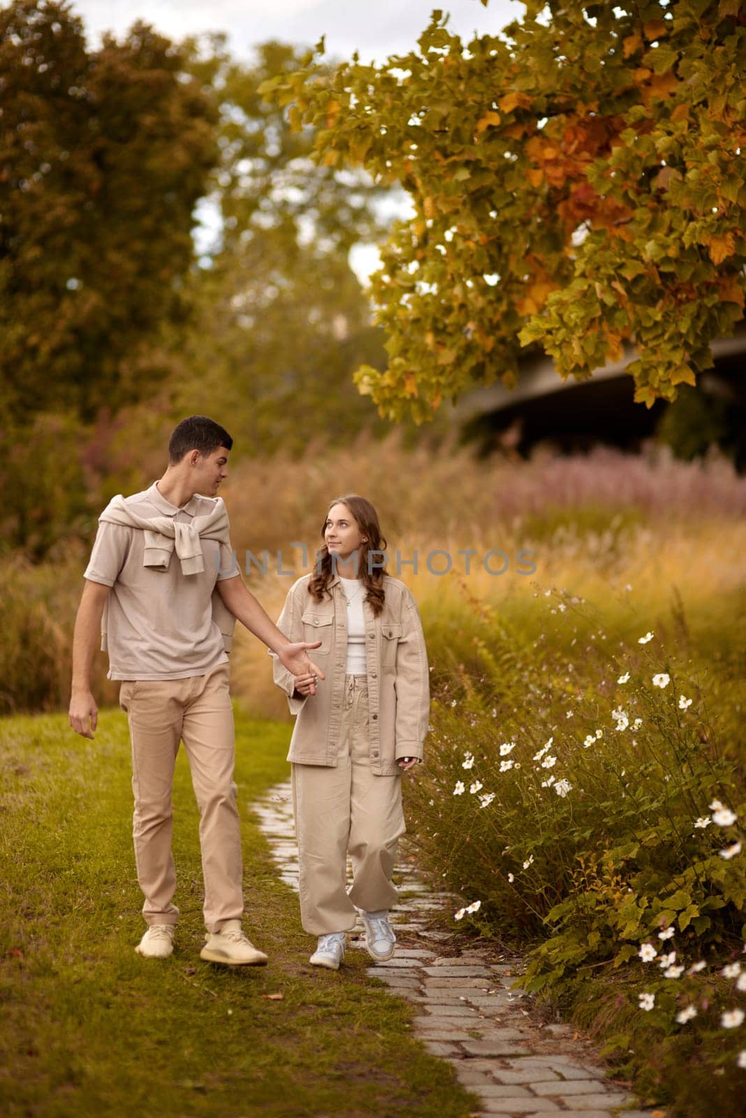 Young Cute Female Hugs Boyfriend. In Autumn Outdoor. Lovers Walking in Park. Attractive Funny Couple. Lovestory in Forest. Man and Woman. Cute Lovers in the Park. Family Concept. Happy Couple.
