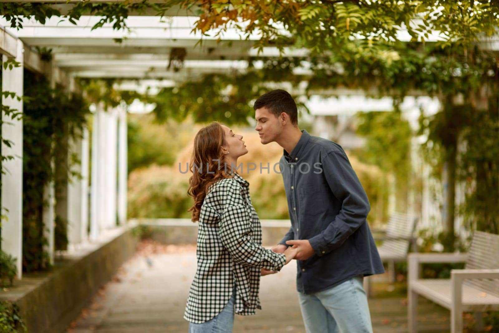 Young Cute Female Hugs Boyfriend. In Autumn Outdoor. Lovers Walking in Park. Attractive Funny Couple. Lovestory in Forest. Man and Woman. Cute Lovers in the Park. Family Concept. Happy Couple.