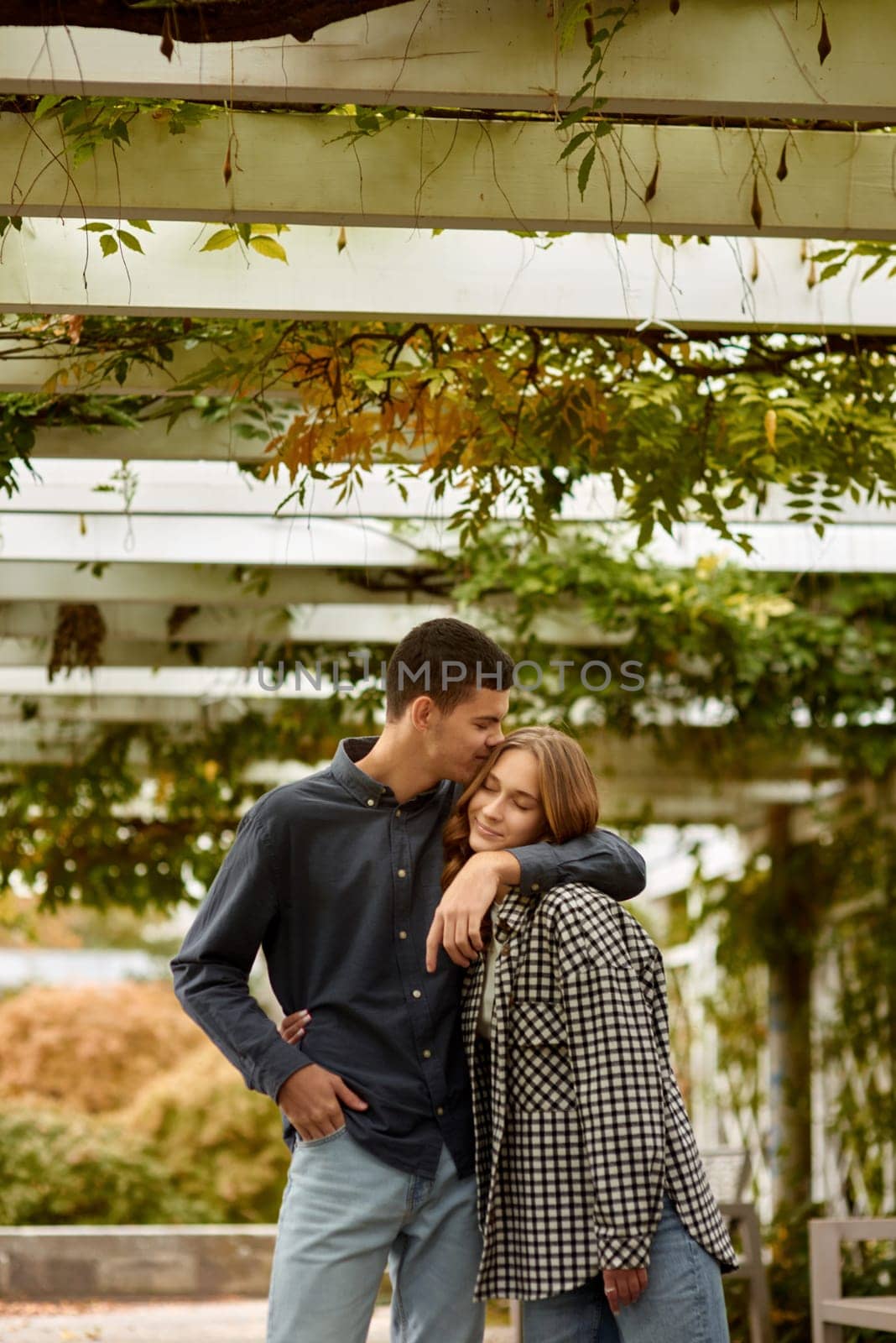 Young Cute Female Hugs Boyfriend. In Autumn Outdoor. Lovers Walking in Park. Attractive Funny Couple. Lovestory in Forest. Man and Woman. Cute Lovers in the Park. Family Concept. Happy Couple. by Andrii_Ko