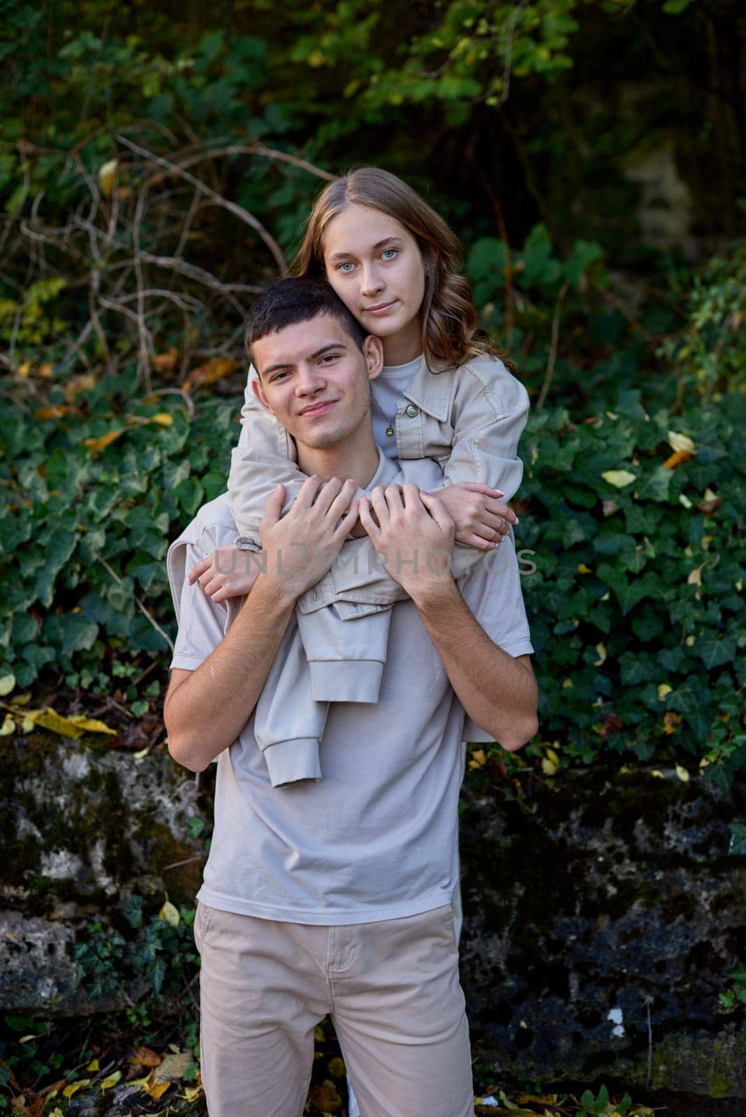 Young Cute Female Hugs Boyfriend. In Autumn Outdoor. Lovers Walking in Park. Attractive Funny Couple. Lovestory in Forest. Man and Woman. Cute Lovers in the Park. Family Concept. Happy Couple.