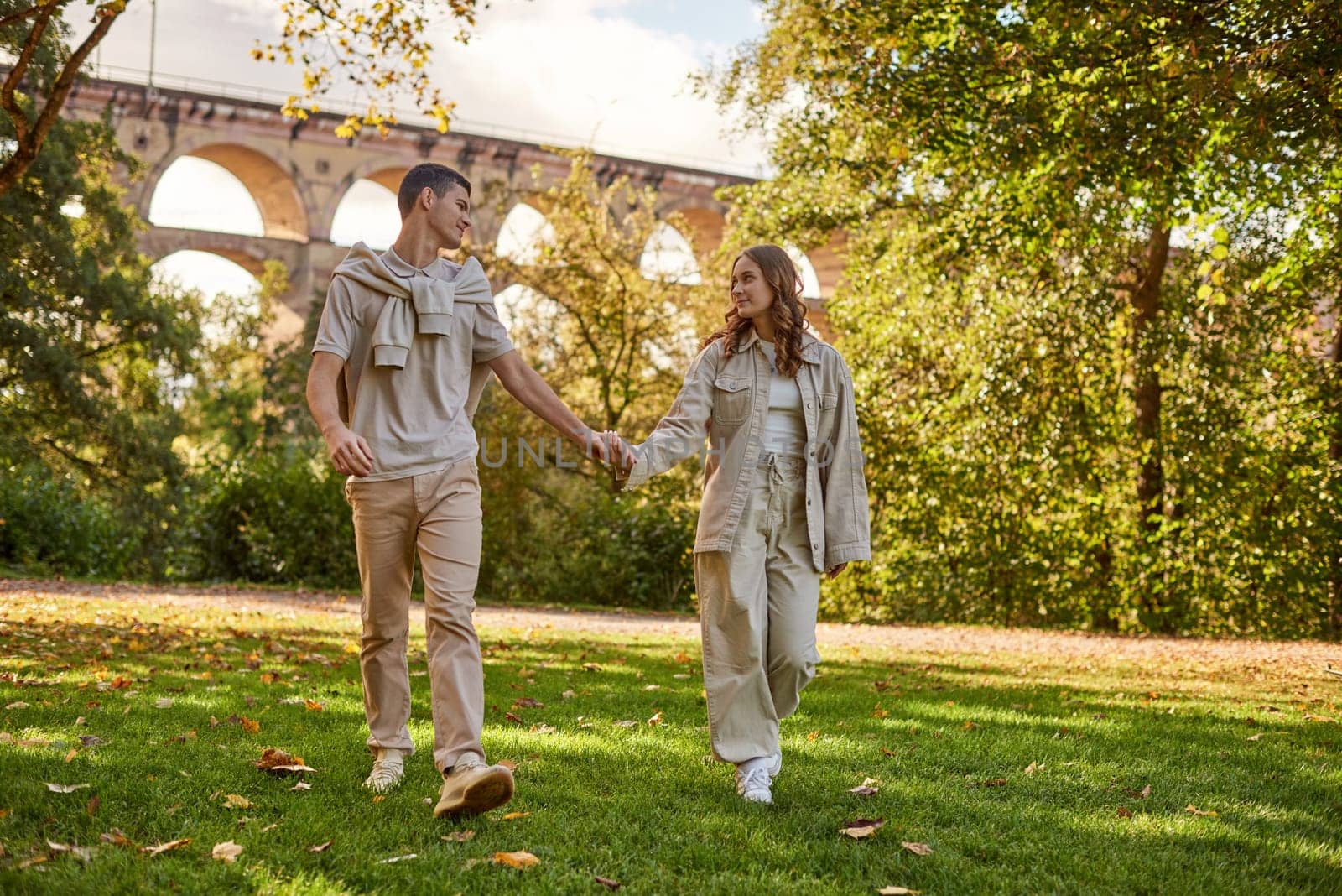 Young Cute Female Hugs Boyfriend. In Autumn Outdoor. Lovers Walking in Park. Attractive Funny Couple. Lovestory in Forest. Man and Woman. Cute Lovers in the Park. Family Concept. Happy Couple. by Andrii_Ko