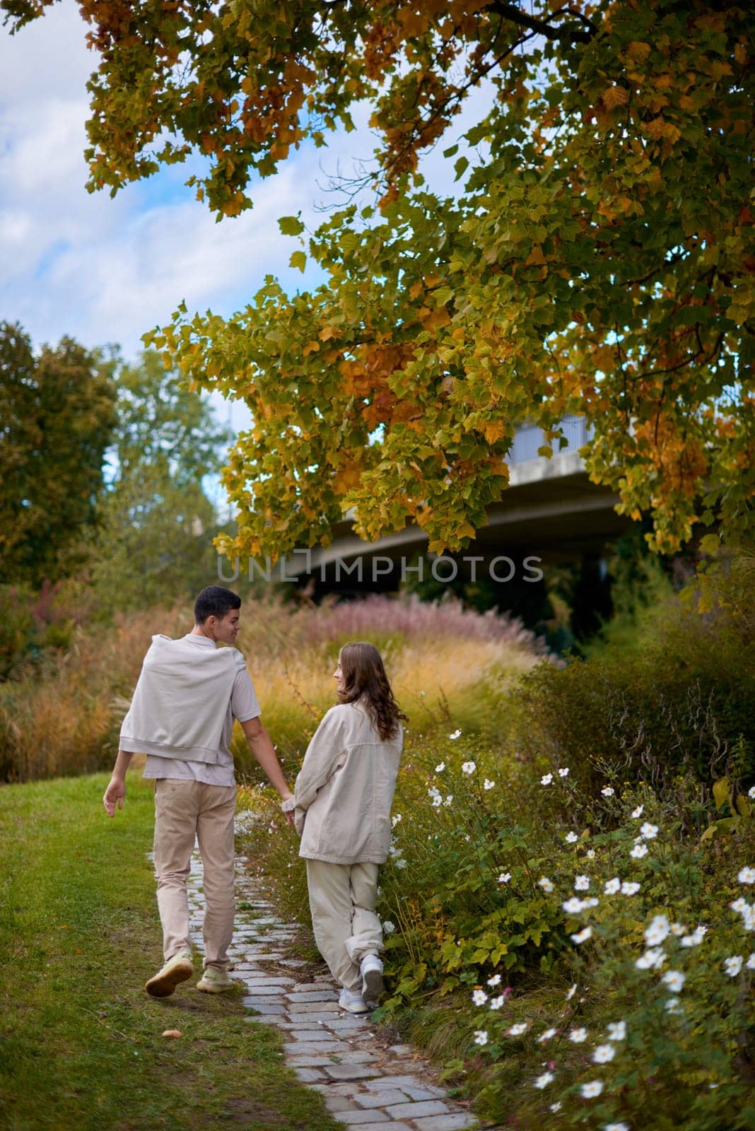 Young Cute Female Hugs Boyfriend. In Autumn Outdoor. Lovers Walking in Park. Attractive Funny Couple. Lovestory in Forest. Man and Woman. Cute Lovers in the Park. Family Concept. Happy Couple.