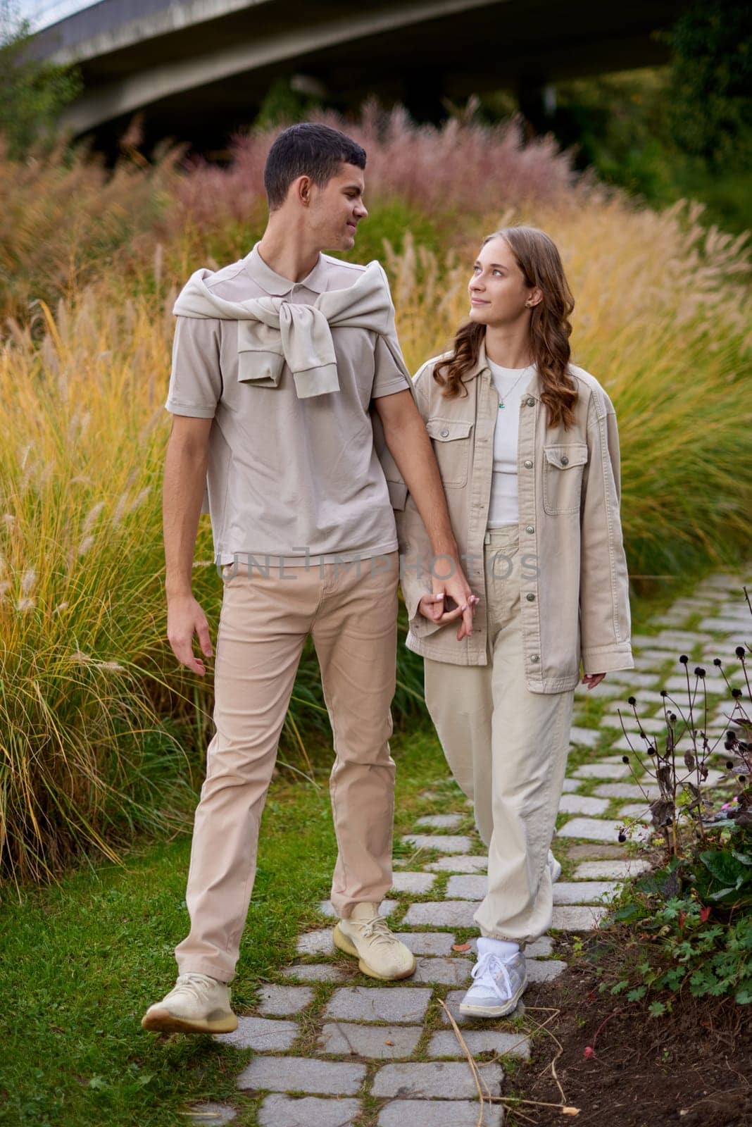 Young Cute Female Hugs Boyfriend. In Autumn Outdoor. Lovers Walking in Park. Attractive Funny Couple. Lovestory in Forest. Man and Woman. Cute Lovers in the Park. Family Concept. Happy Couple.