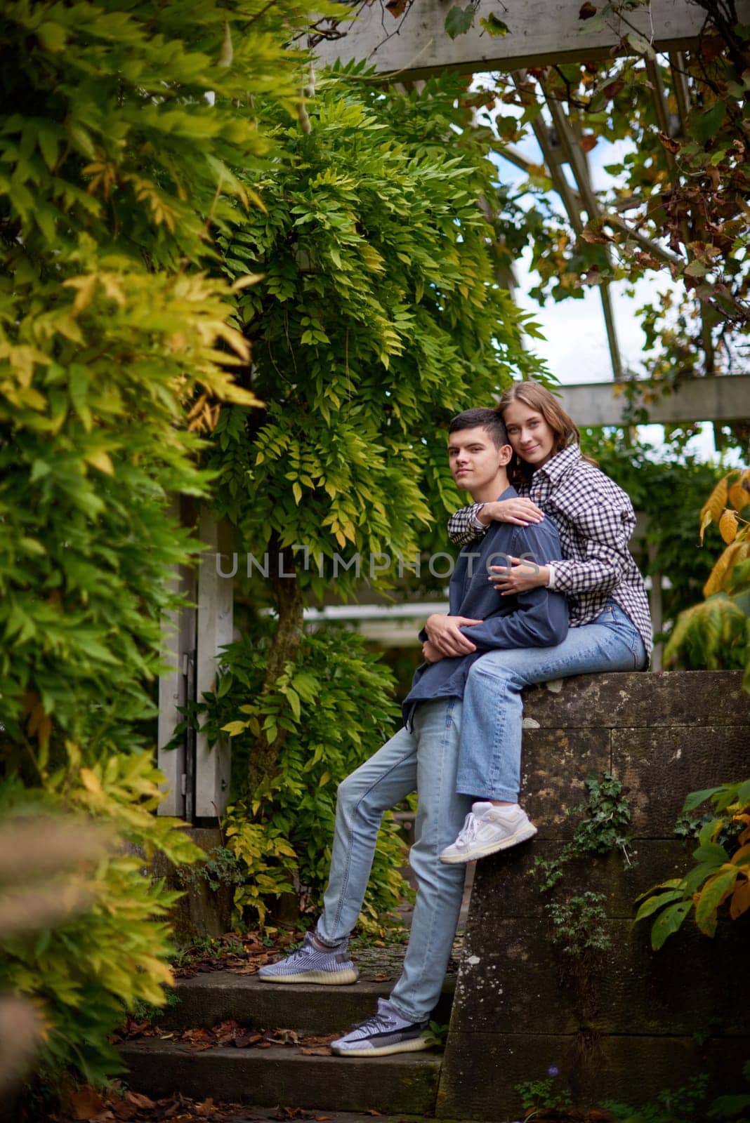 Young Cute Female Hugs Boyfriend. In Autumn Outdoor. Lovers Walking in Park. Attractive Funny Couple. Lovestory in Forest. Man and Woman. Cute Lovers in the Park. Family Concept. Happy Couple. by Andrii_Ko