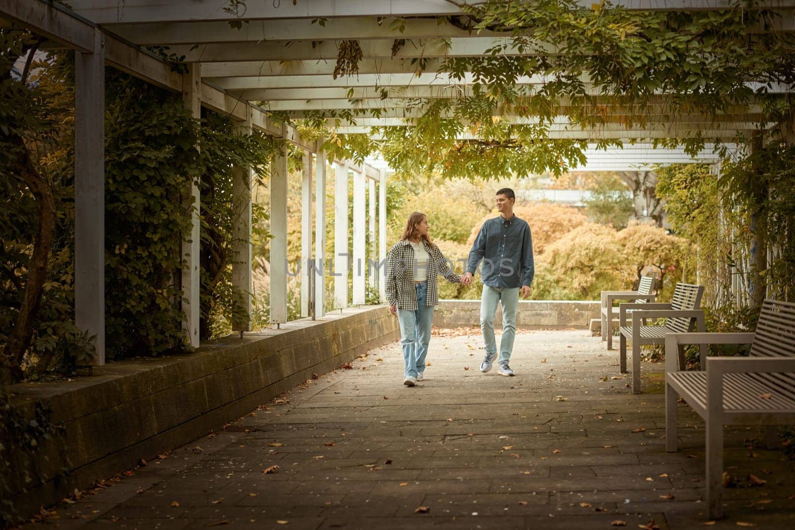 Young Cute Female Hugs Boyfriend. In Autumn Outdoor. Lovers Walking in Park. Attractive Funny Couple. Lovestory in Forest. Man and Woman. Cute Lovers in the Park. Family Concept. Happy Couple.