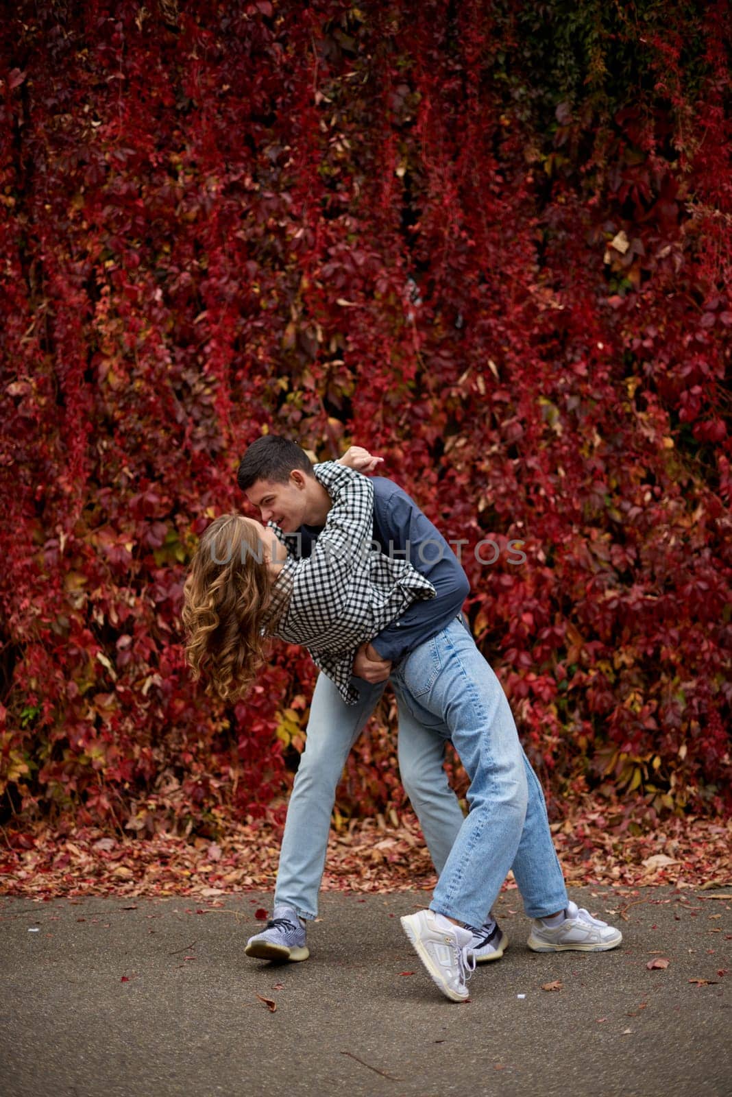 Young Cute Female Hugs Boyfriend. In Autumn Outdoor. Lovers Walking in Park. Attractive Funny Couple. Lovestory in Forest. Man and Woman. Cute Lovers in the Park. Family Concept. Happy Couple.