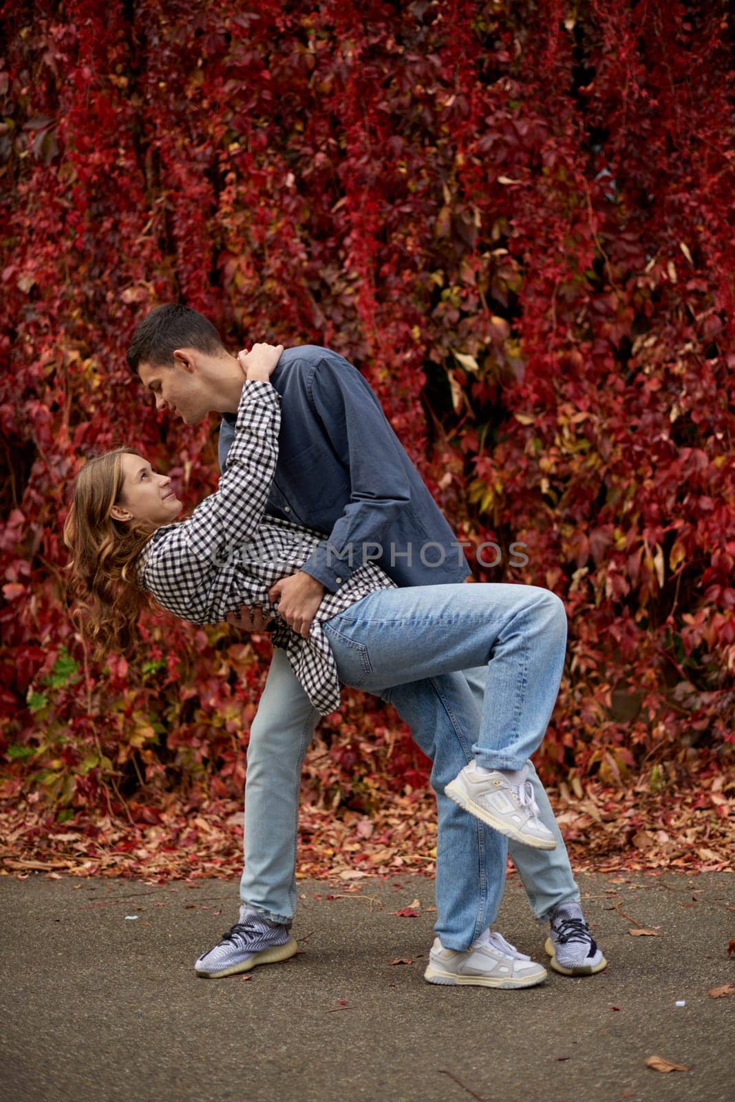 Young Cute Female Hugs Boyfriend. In Autumn Outdoor. Lovers Walking in Park. Attractive Funny Couple. Lovestory in Forest. Man and Woman. Cute Lovers in the Park. Family Concept. Happy Couple. by Andrii_Ko