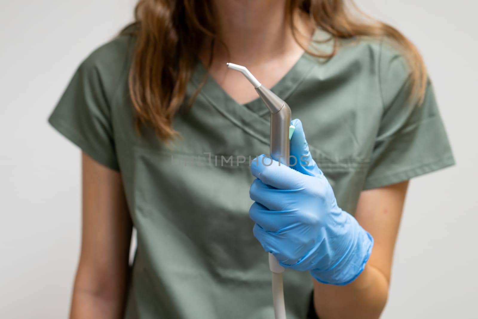 Air and Water Syringe in dentist hand in rubber gloves.