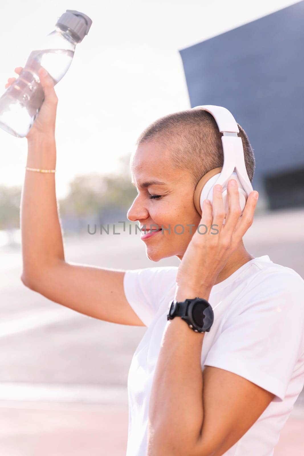 vertical photo of a young woman dancing and smiling happy while listening to music in headphones, concept of rhythm and happiness
