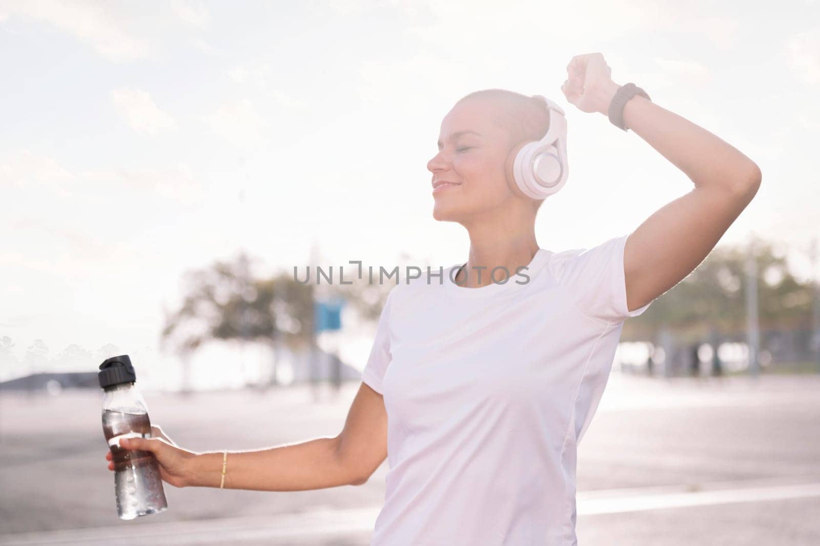 young woman dancing and smiling happy while listening to music in headphones, concept of rhythm and happiness, copy space for text