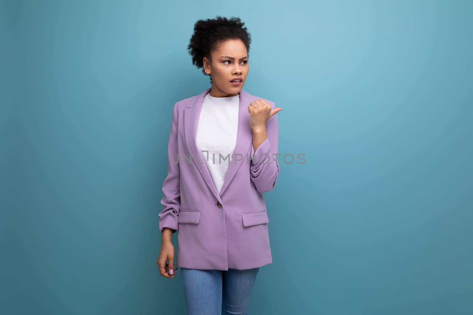 young latin business woman with ponytail hairstyle dressed in purple jacket on studio background with copy space.
