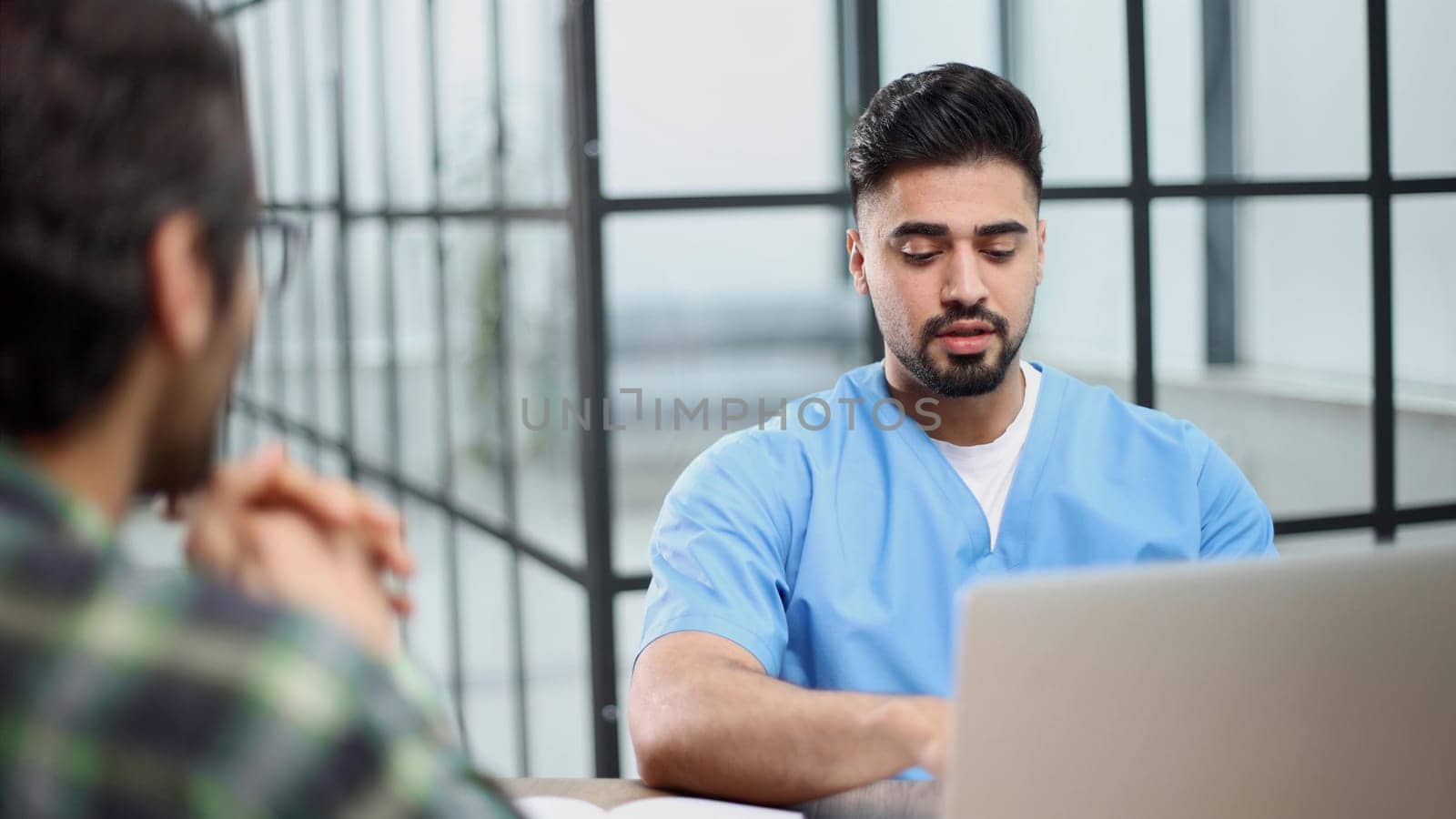 male doctor consulting patient filling form at consultation.