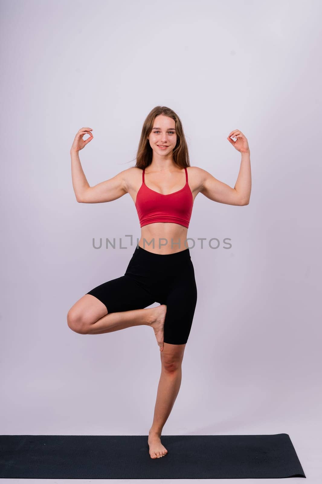 Beautiful female in yoga studio. A woman doing yoga. Lady in a top.