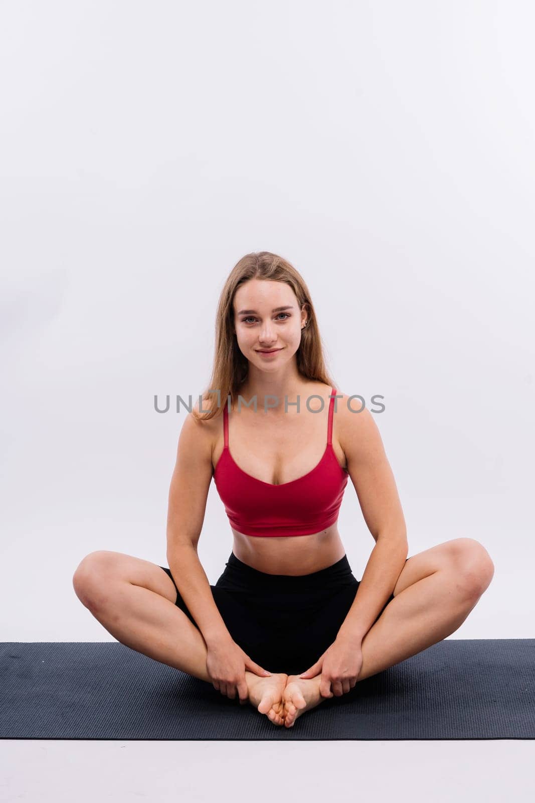 Beautiful female in yoga studio. A woman doing yoga. Lady in a top.