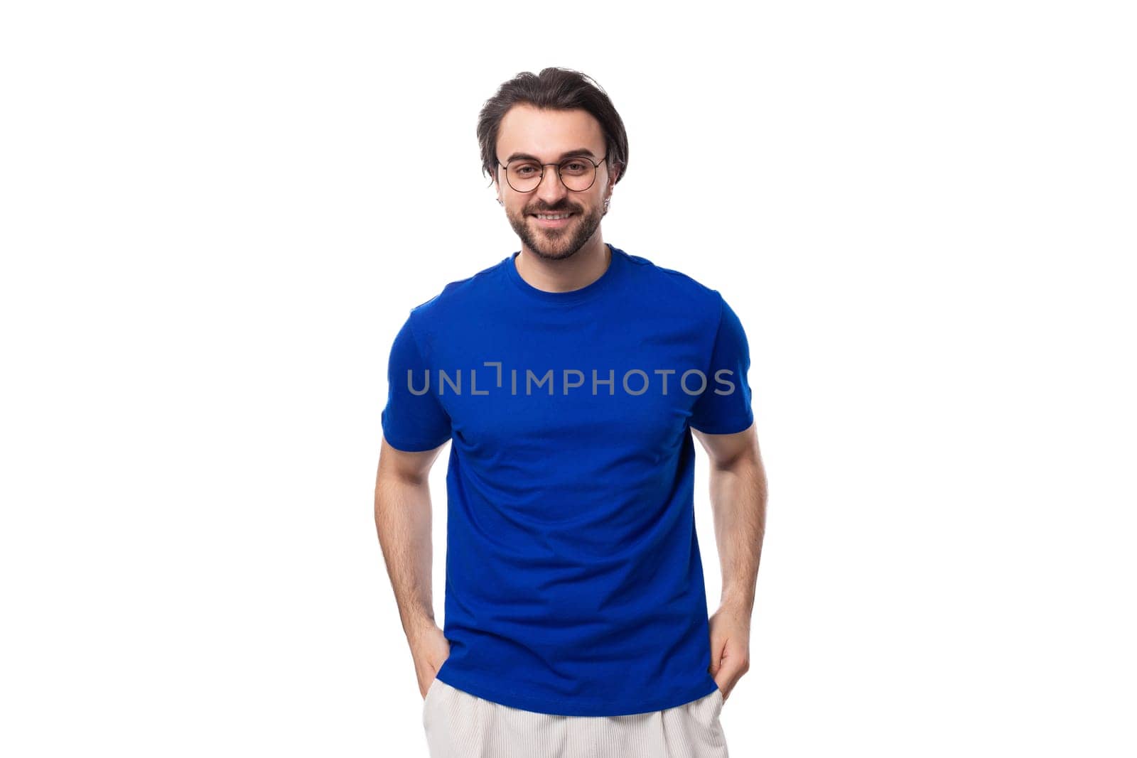 portrait of a young brunette man with a well-groomed beard dressed in a blue t-shirt on a white background with copy space.